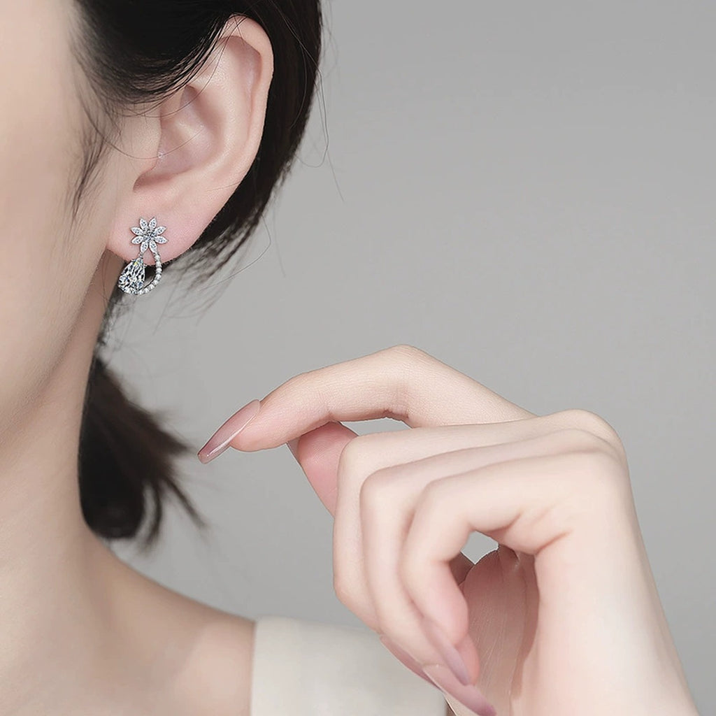 Pear Cut Moissanite Stud Drop Earrings with CZ in Rhodium-Plated S925 sterling silver worn on ear by model showing scale, placement, and stud earrings styling