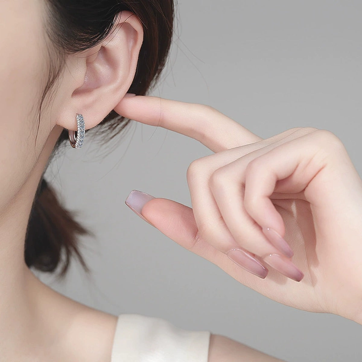 Pave Moissanite Hoop Earrings in Rhodium-Plated S925 sterling silver worn on ear by model showing scale, placement, and hoop earrings styling