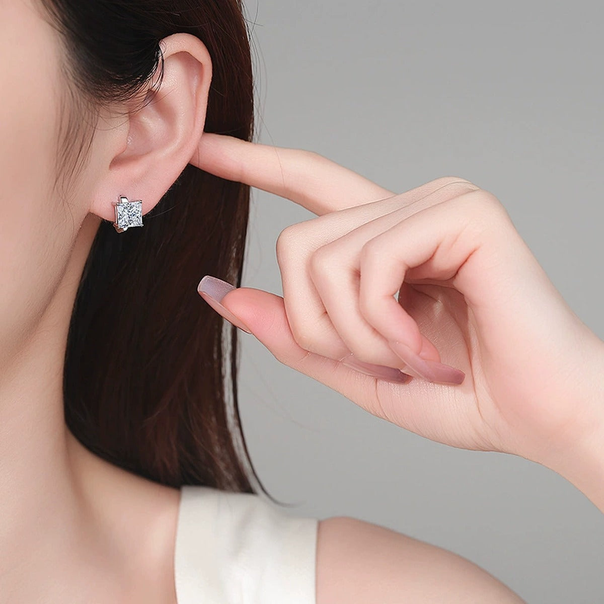 Princess Cut Moissanite Huggie Hoop Earrings in Rhodium-Plated S925 sterling silver worn on ear by model showing scale, placement, and huggie hoop earrings styling