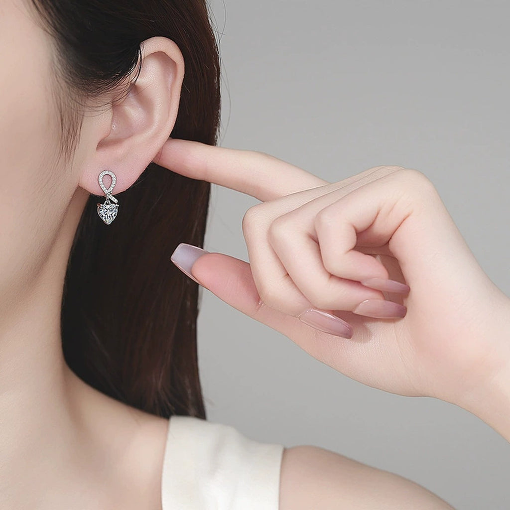 Heart Moissanite Stud Dangle Earrings with CZ in Rhodium-Plated S925 sterling silver worn on ear by model showing scale, placement, and stud dangle earrings styling