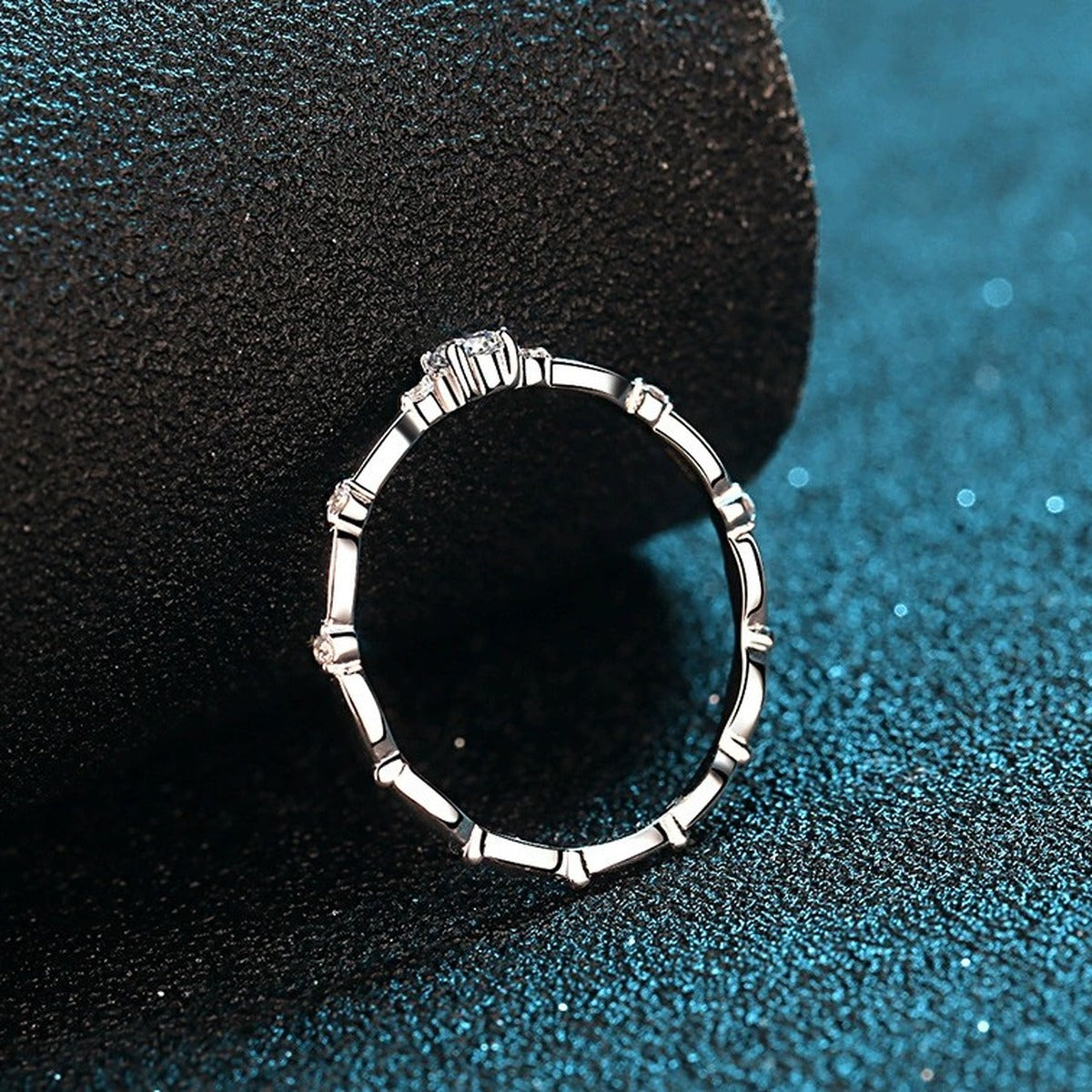 Twist Moissanite Band Ring with CZ in Rhodium-Plated S925 Sterling Silver blue display product photo showing the moissanite setting and band profile
