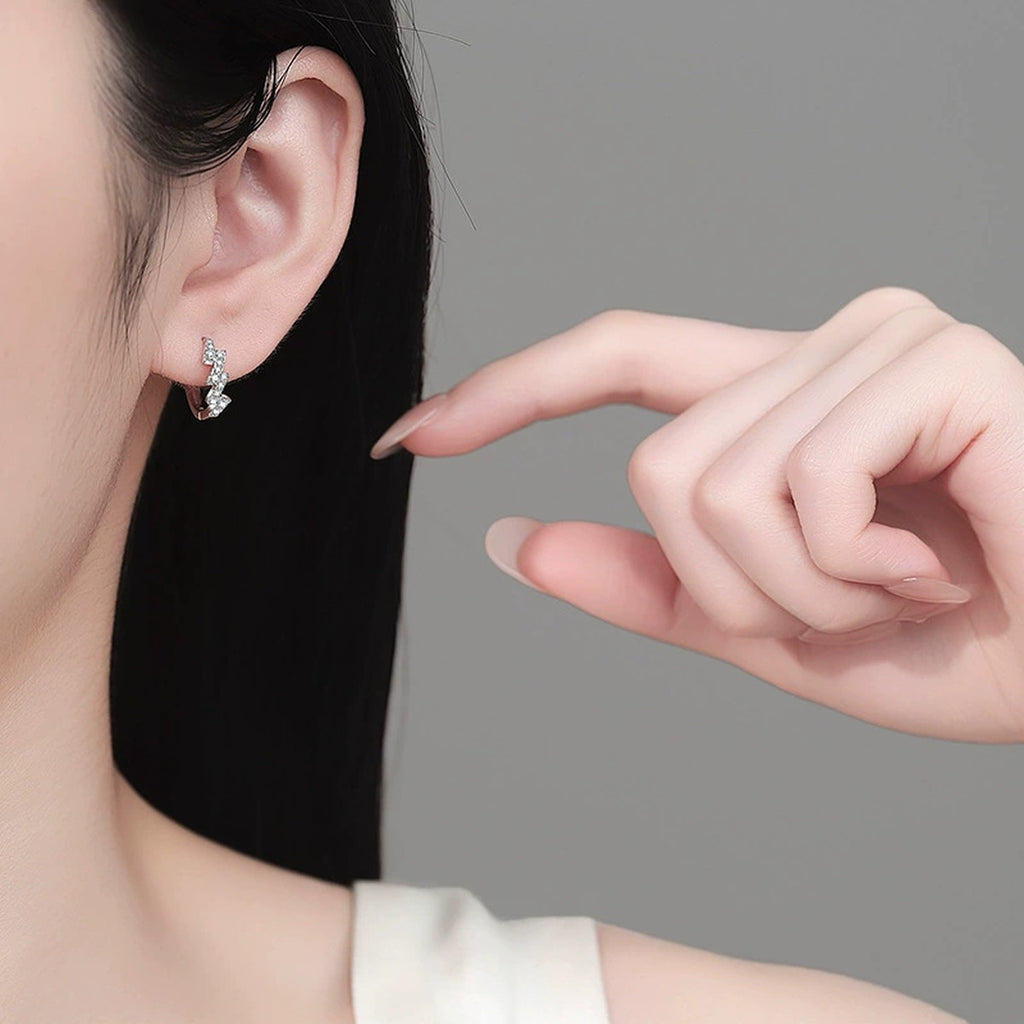 Wave Moissanite Huggie Hoop Earrings in Rhodium-Plated S925 sterling silver worn on ear by model showing scale, placement, and huggie hoop earrings styling