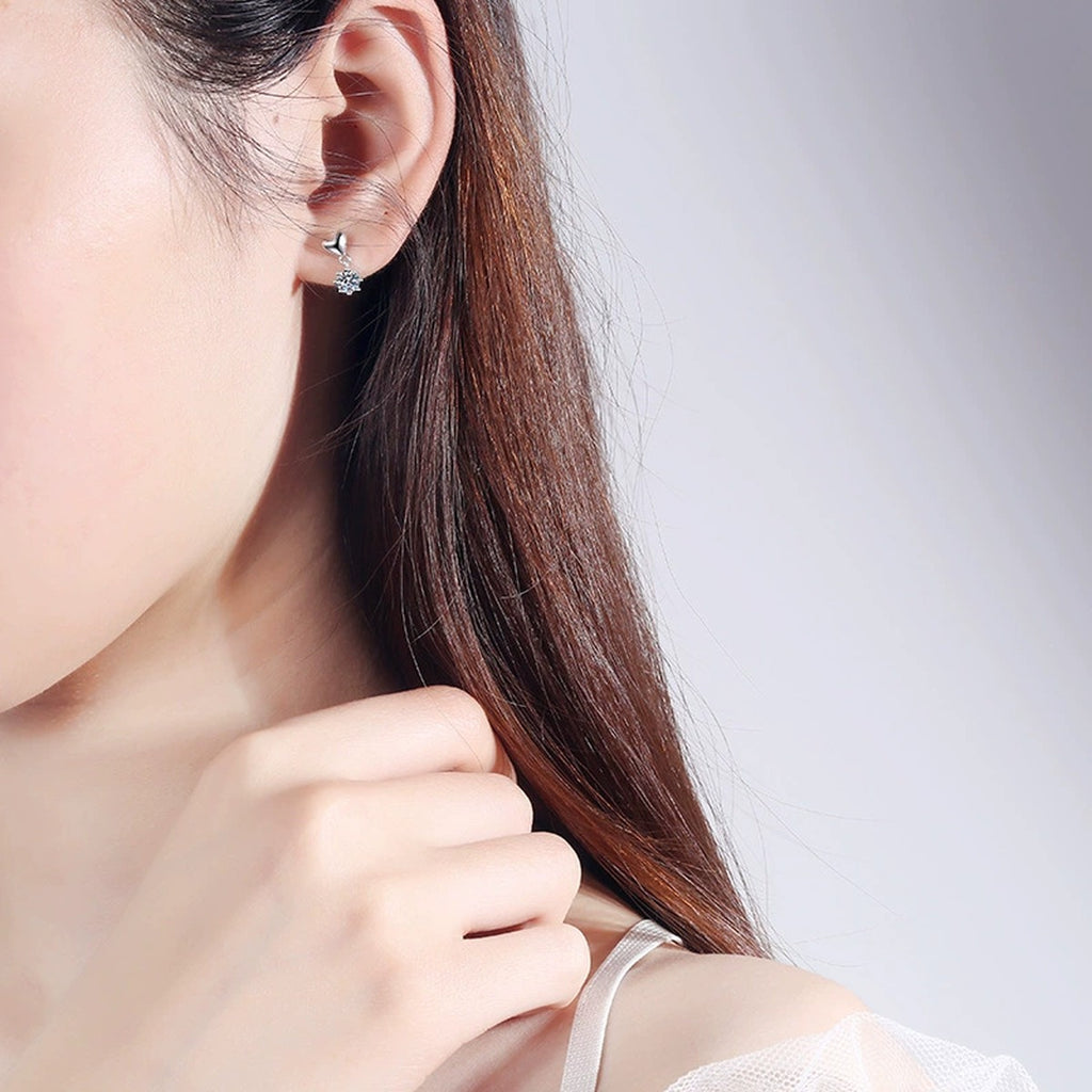 Heart Moissanite Stud Dangle Earrings in Rhodium-Plated S925 Sterling Silver worn on ear by model to show scale, drop length, and everyday styling