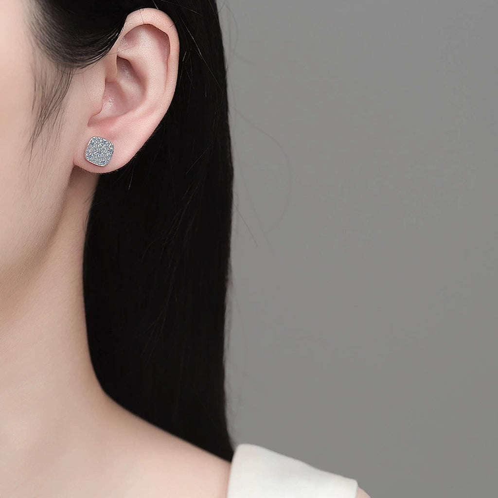 Cushion Cluster Moissanite Stud Earrings in Rhodium-Plated S925 sterling silver worn on ear by model showing scale, placement, and stud earrings styling