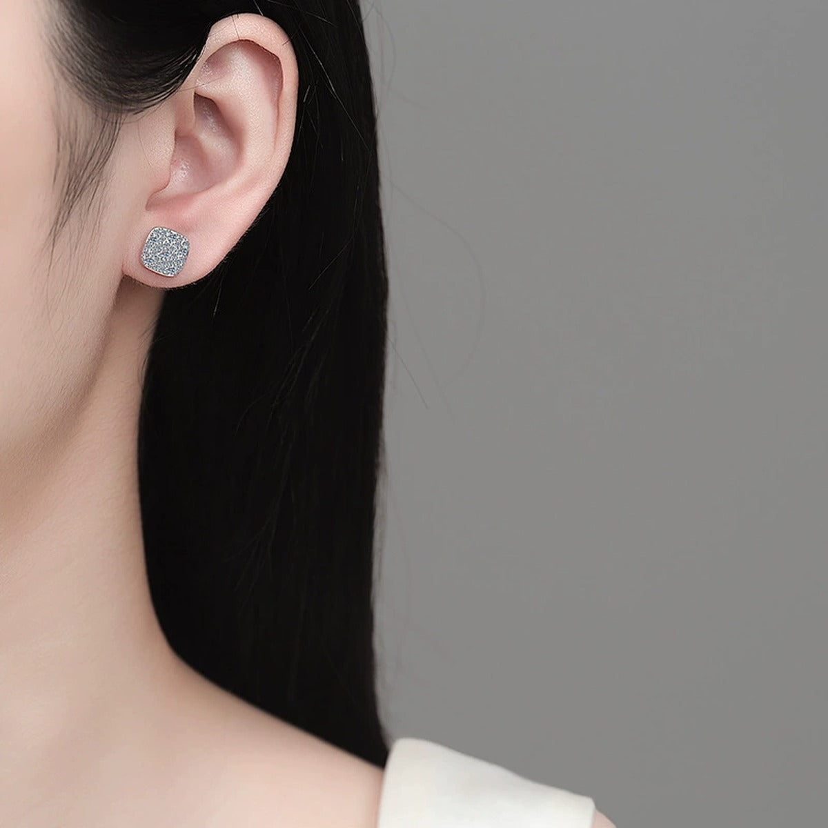 Cushion Cluster Moissanite Stud Earrings in Rhodium-Plated S925 sterling silver worn on ear by model showing scale, placement, and stud earrings styling