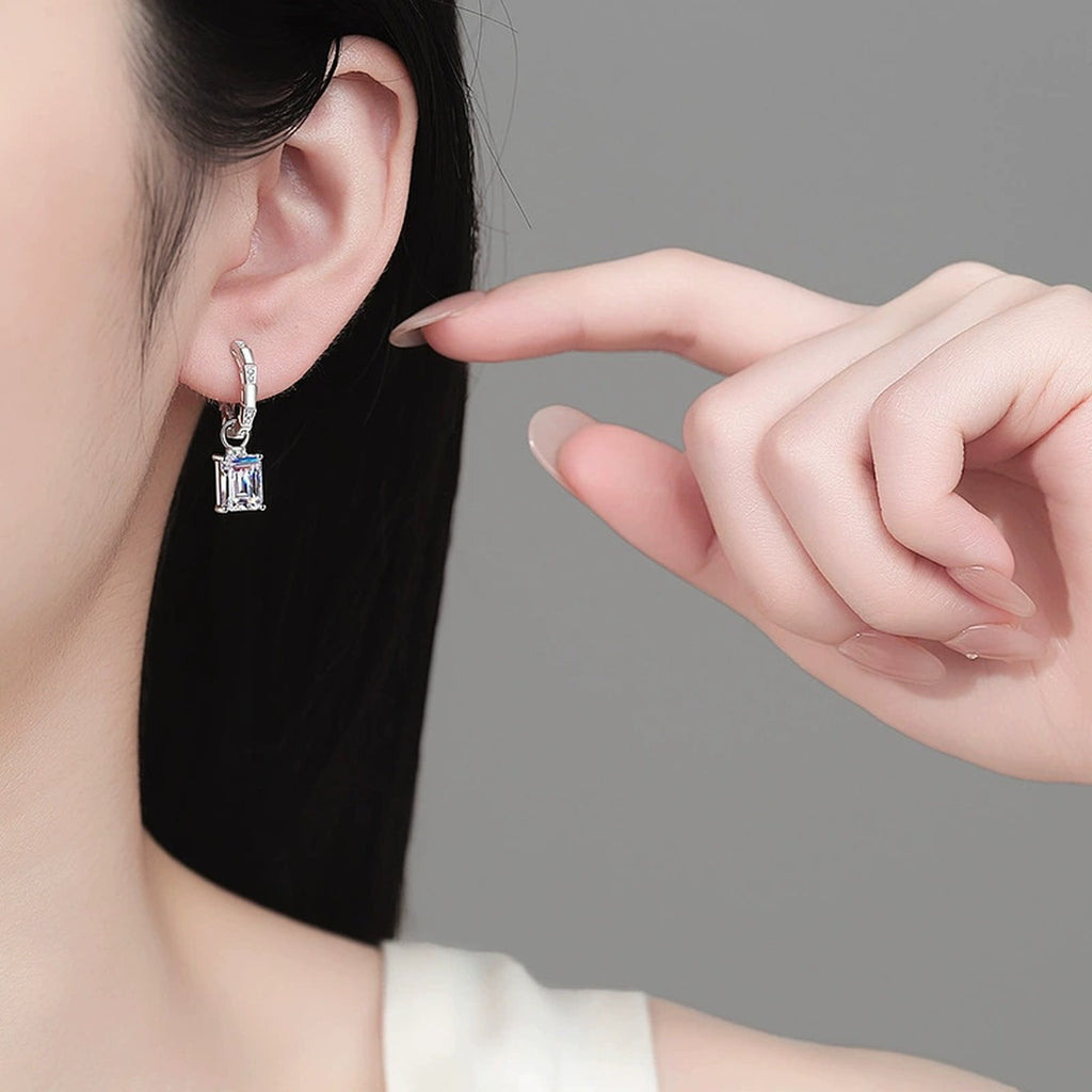 Emerald and Radiant Cut Moissanite Hoop Dangle Earrings in Rhodium-Plated S925 sterling silver worn on ear by model showing scale, placement, and hoop dangle earrings styling