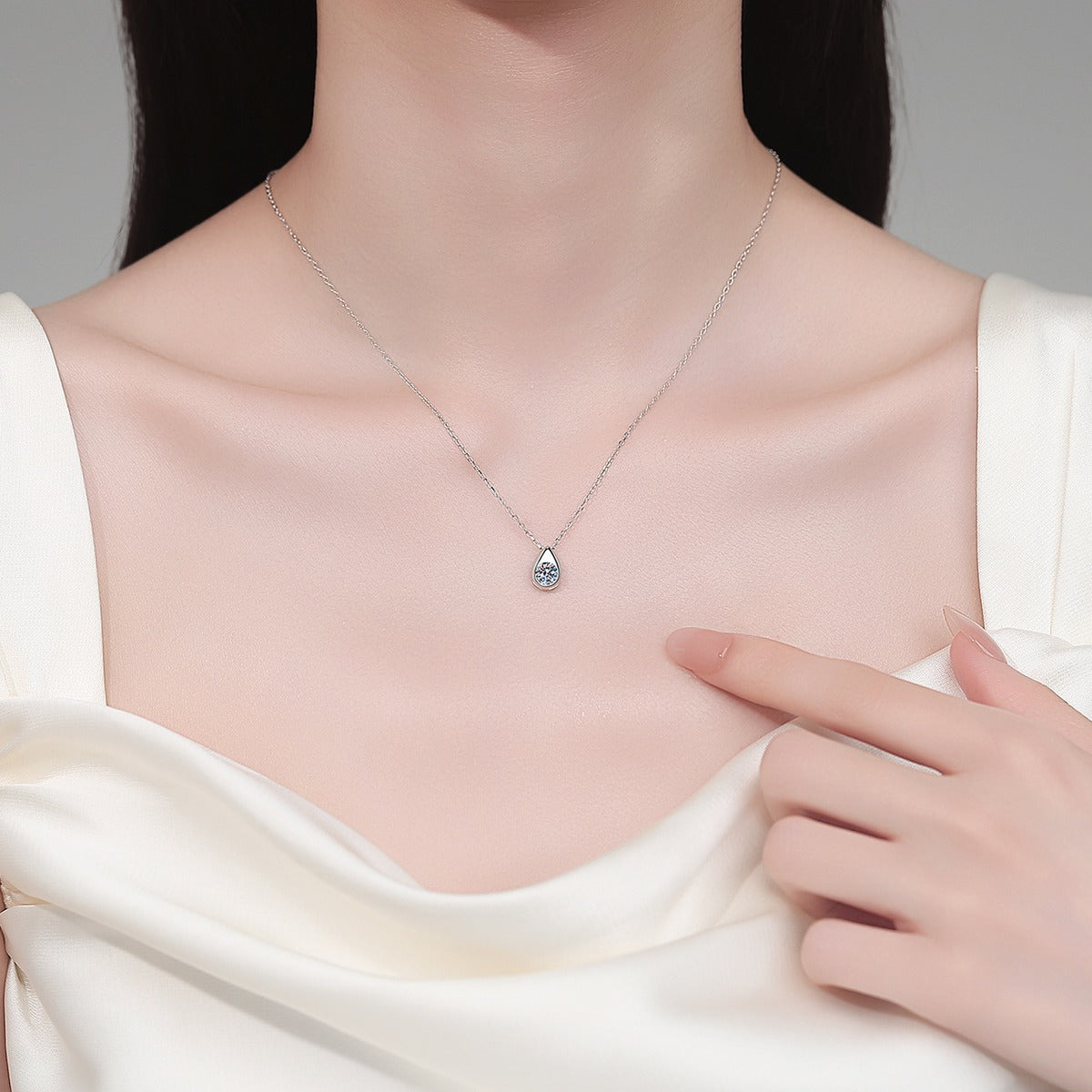 Teardrop Round Moissanite Pendant Necklace in Rhodium-Plated S925 sterling silver neckline model view showing pendant scale and adjustable chain