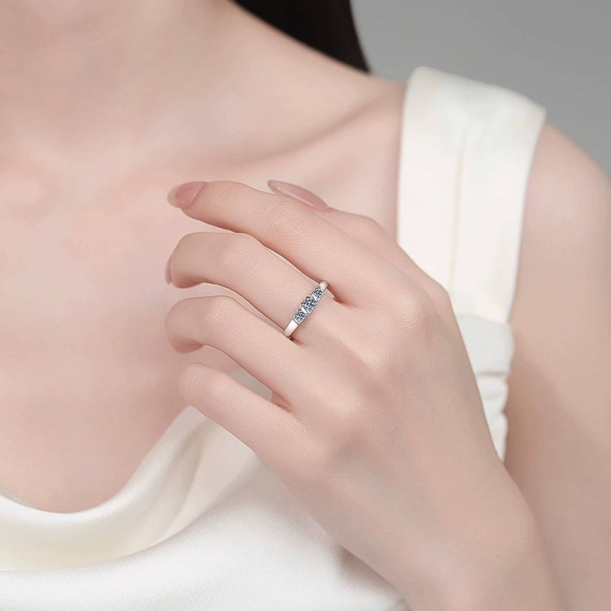 Round Moissanite Five Stone Ring worn on hand to show scale, band width, and ring profile