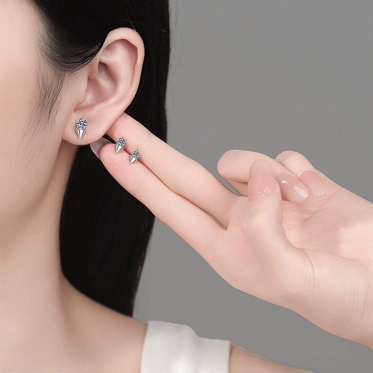 Round Moissanite Stud Earrings in Rhodium-Plated S925 sterling silver worn on ear by model showing scale, placement, and stud earrings styling