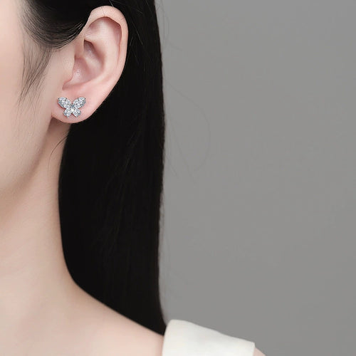 Butterfly Moissanite Stud Earrings in Rhodium-Plated S925 sterling silver worn on ear by model showing scale, placement, and stud earrings styling
