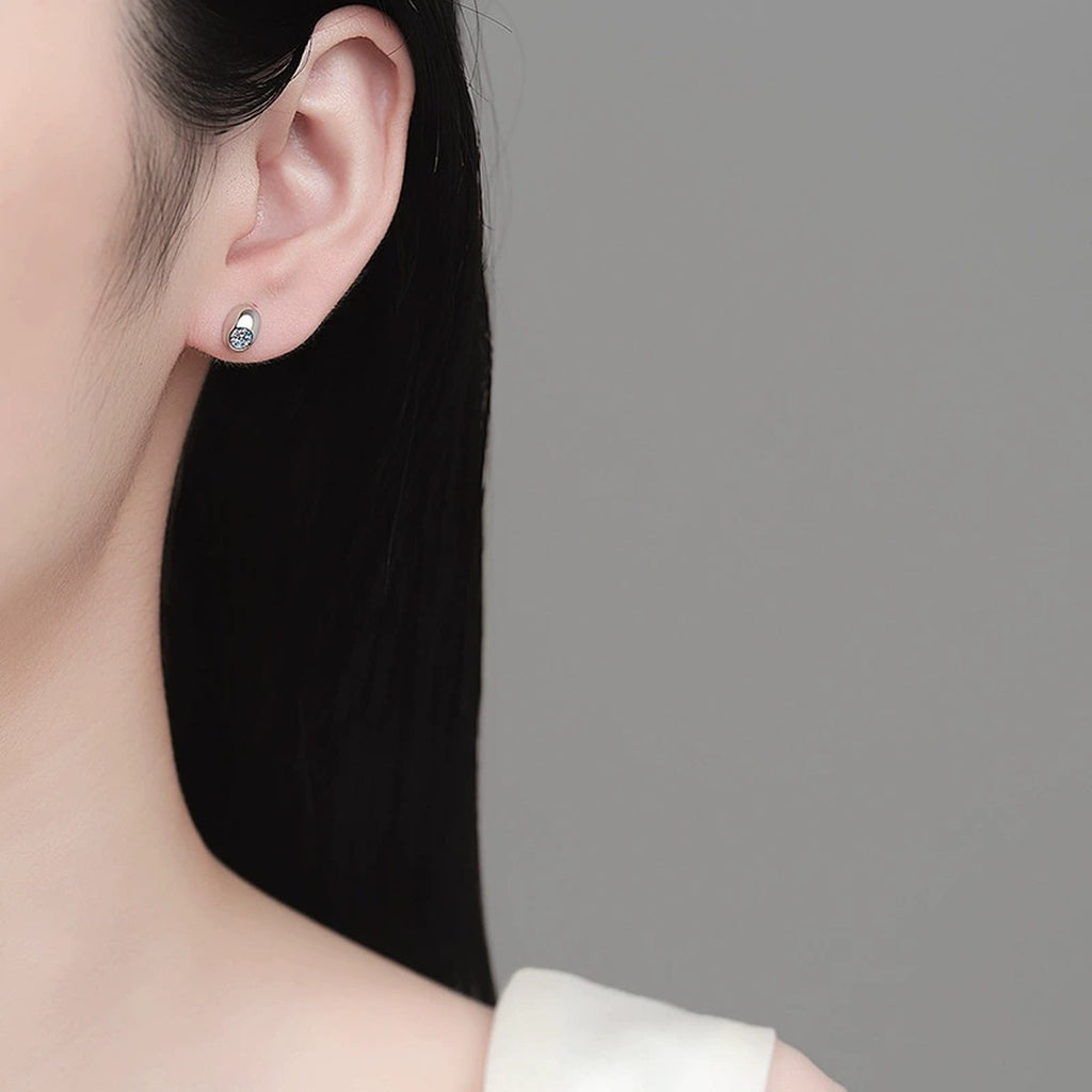 Round Moissanite Oval Stud Earrings in Rhodium-Plated S925 sterling silver worn on ear by model showing scale, placement, and stud earrings styling