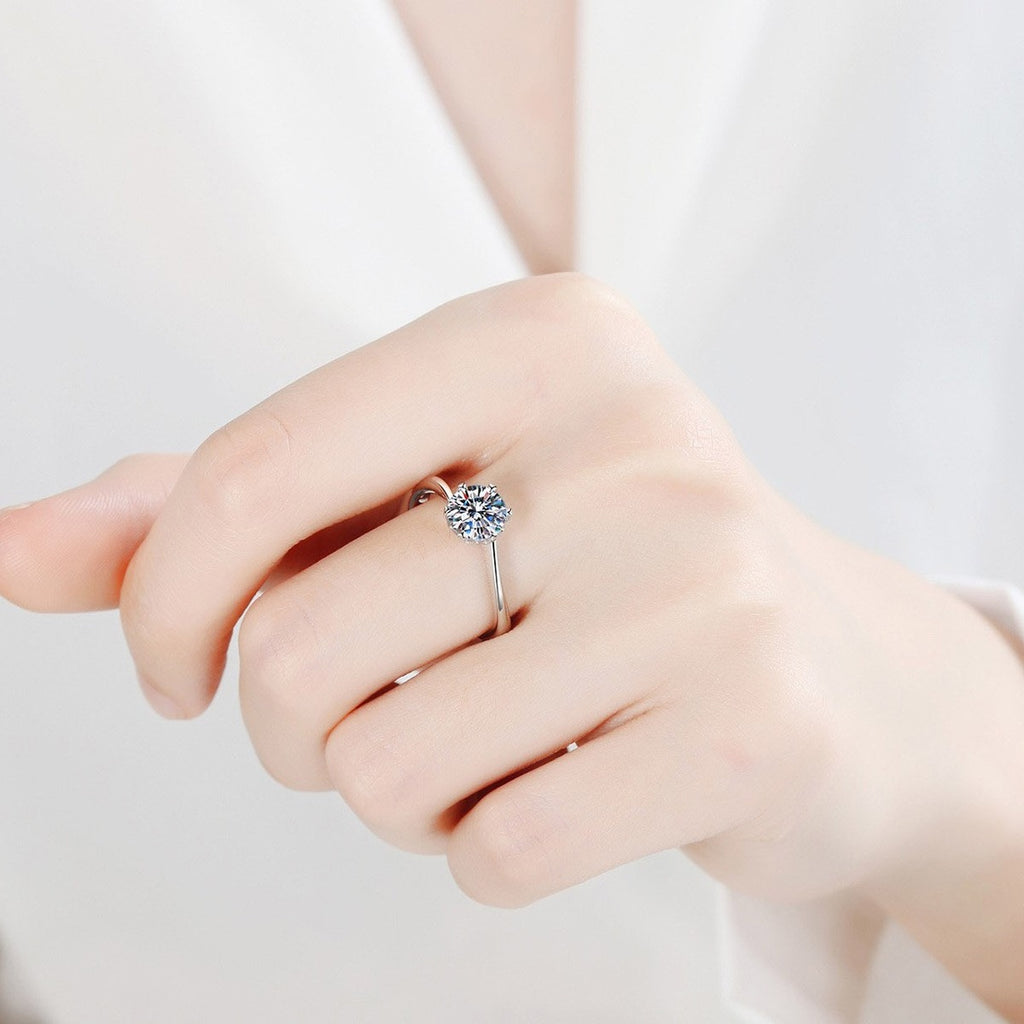 Round Moissanite Solitaire Engagement Ring worn on hand to show scale, band width, and ring profile