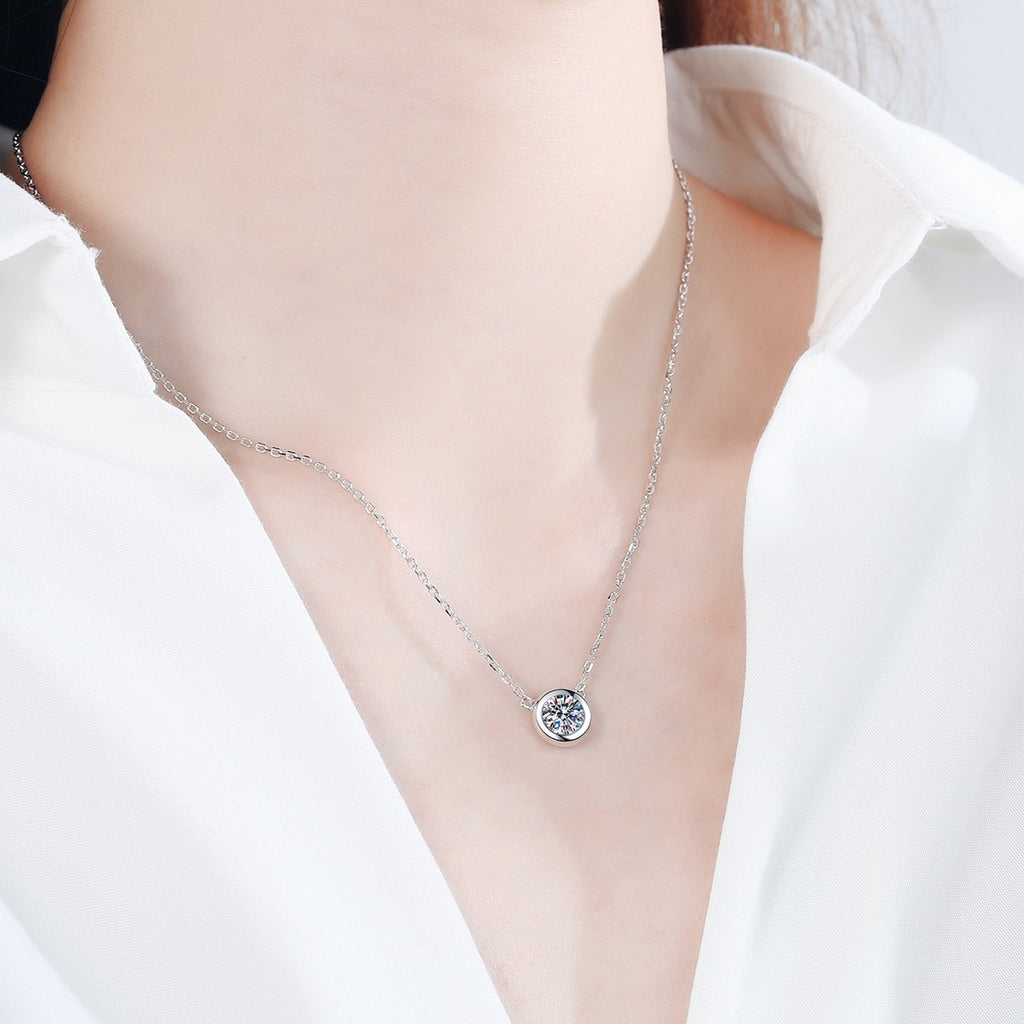 Bezel Solitaire Moissanite Necklace in Rhodium-Plated S925 sterling silver worn on neckline by model showing scale and adjustable chain styling