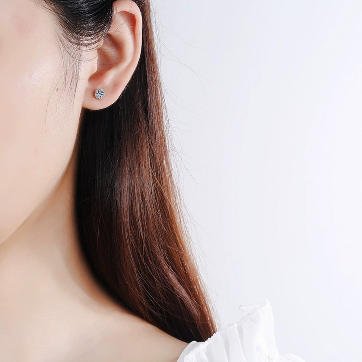 Round Moissanite Stud Earrings in Rhodium-Plated S925 Sterling Silver ear model view showing scale and the round stud on the ear