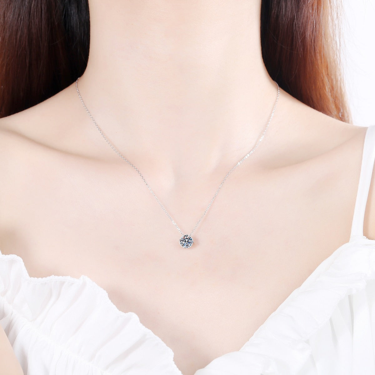 Solitaire Moissanite Pendant Necklace in Rhodium-Plated S925 sterling silver worn on neckline by model showing scale and adjustable chain styling