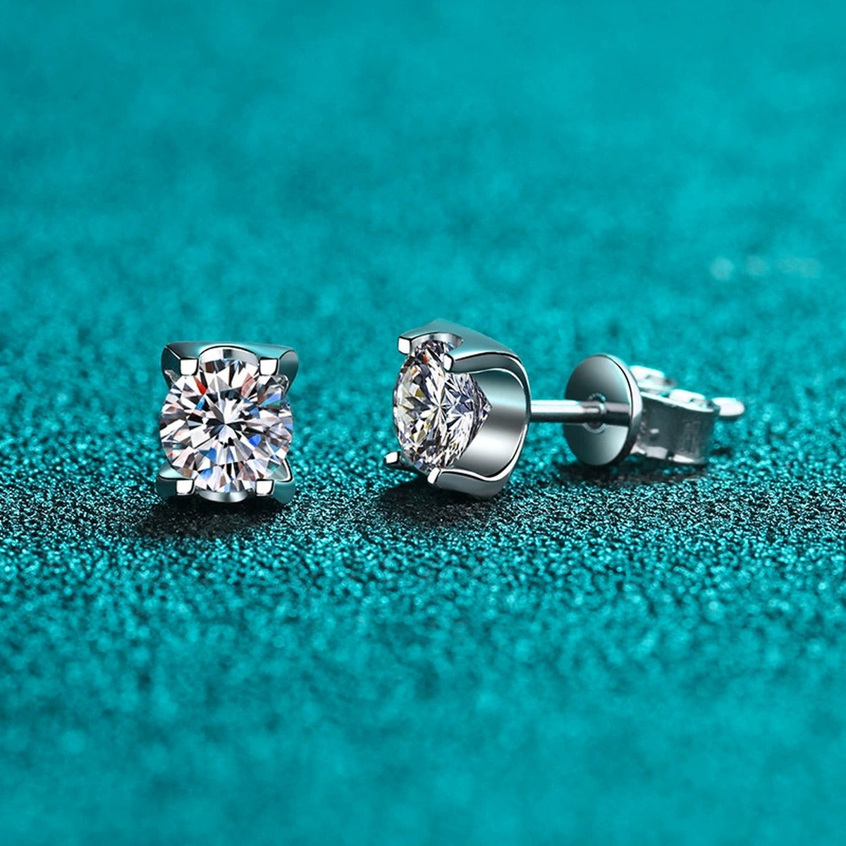 Square Moissanite Stud Earrings with CZ in Rhodium-Plated S925 Sterling Silver on blue-green fabric showing side profile and stone setting