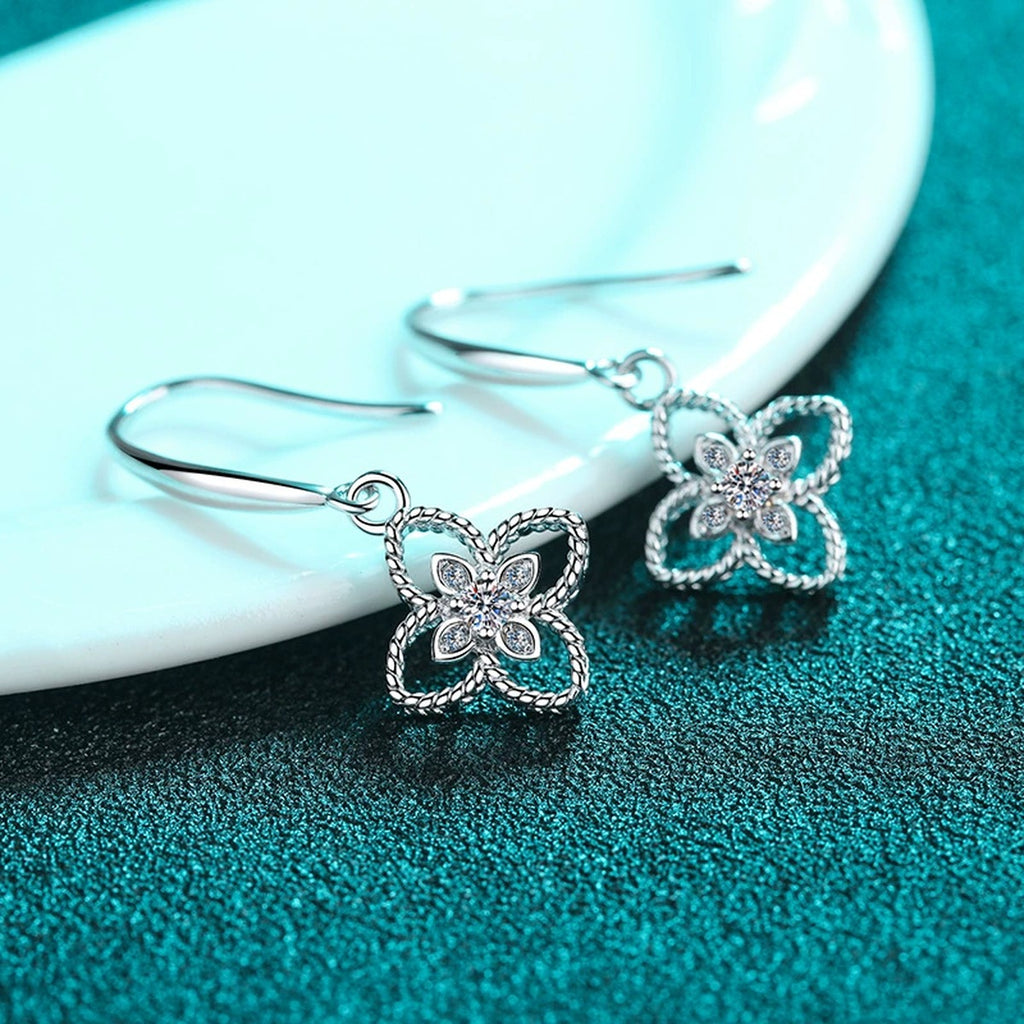 Floral Moissanite Hook Dangle Earrings in Rhodium-Plated S925 Sterling Silver on blue-green fabric showing side profile and stone setting