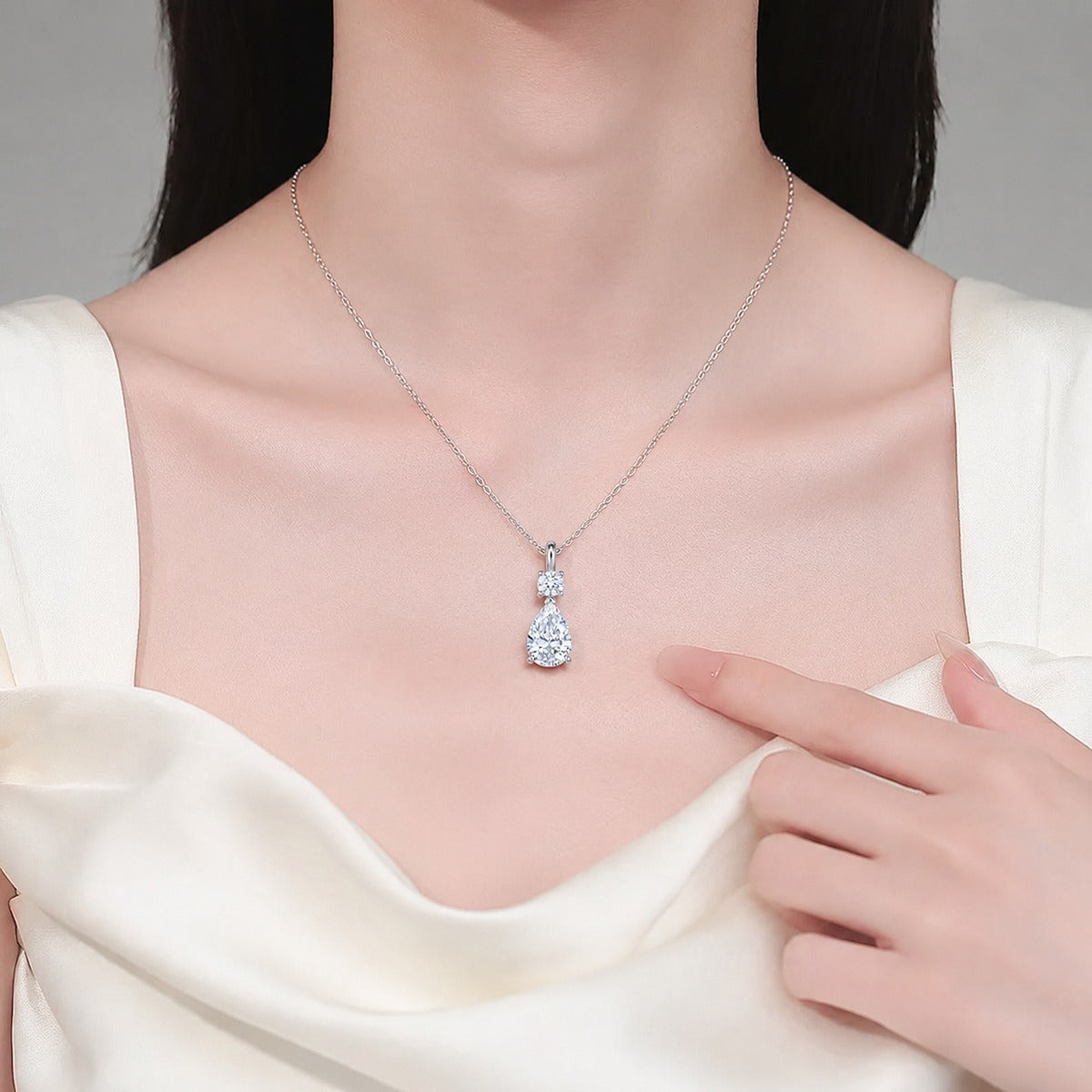 Pear and Round Moissanite Drop Necklace in Rhodium-Plated S925 sterling silver neckline model view showing pendant scale and adjustable chain