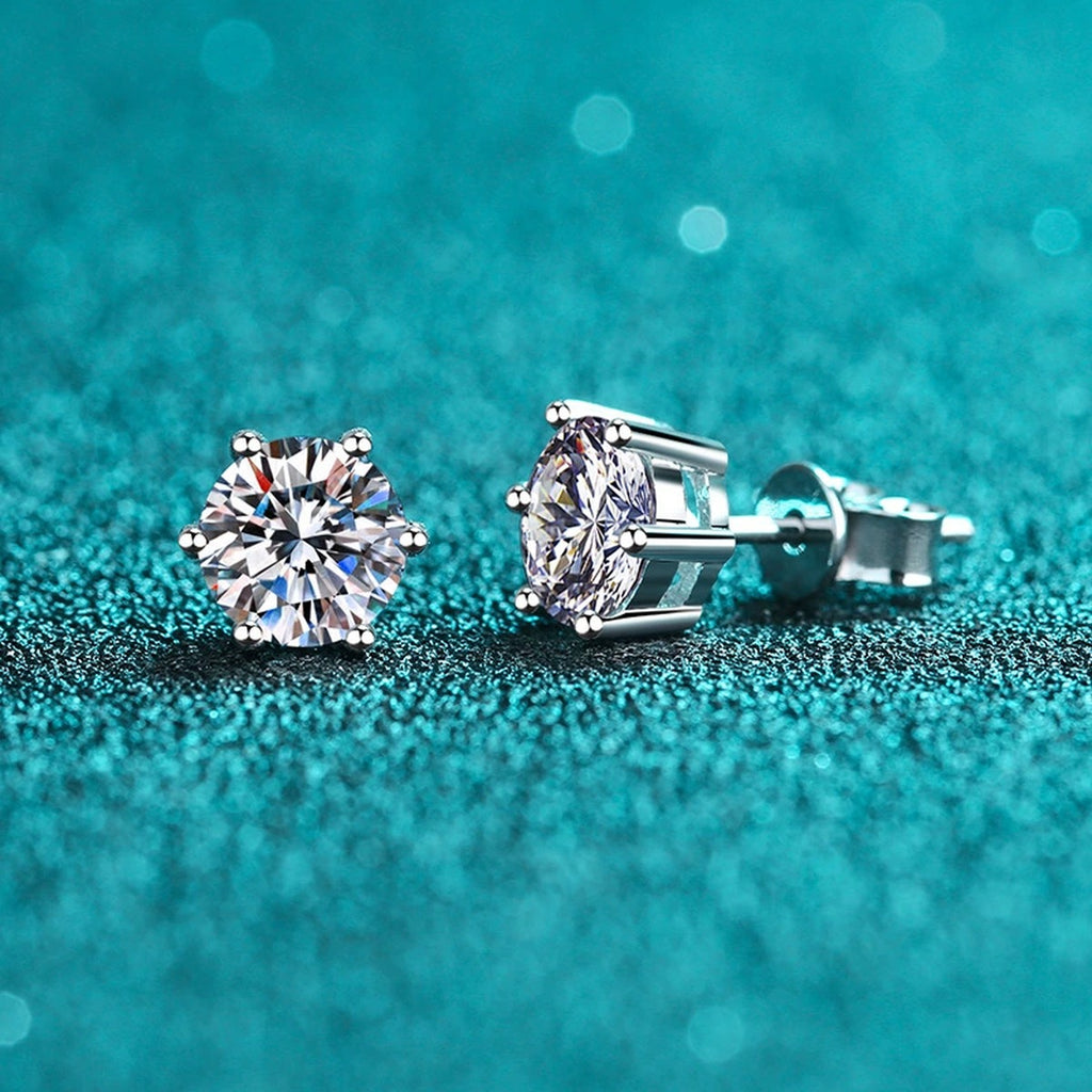Classic Round Moissanite Stud Earrings in Rhodium-Plated S925 Sterling Silver on blue-green fabric showing front detail