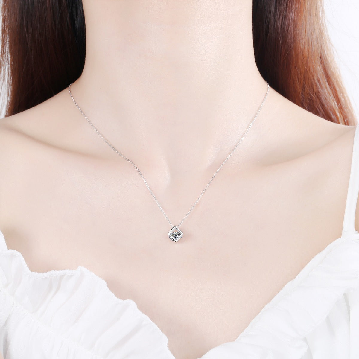 Magic Cube Moissanite Pendant Necklace in Rhodium-Plated S925 sterling silver worn on neckline by model showing scale and adjustable chain styling