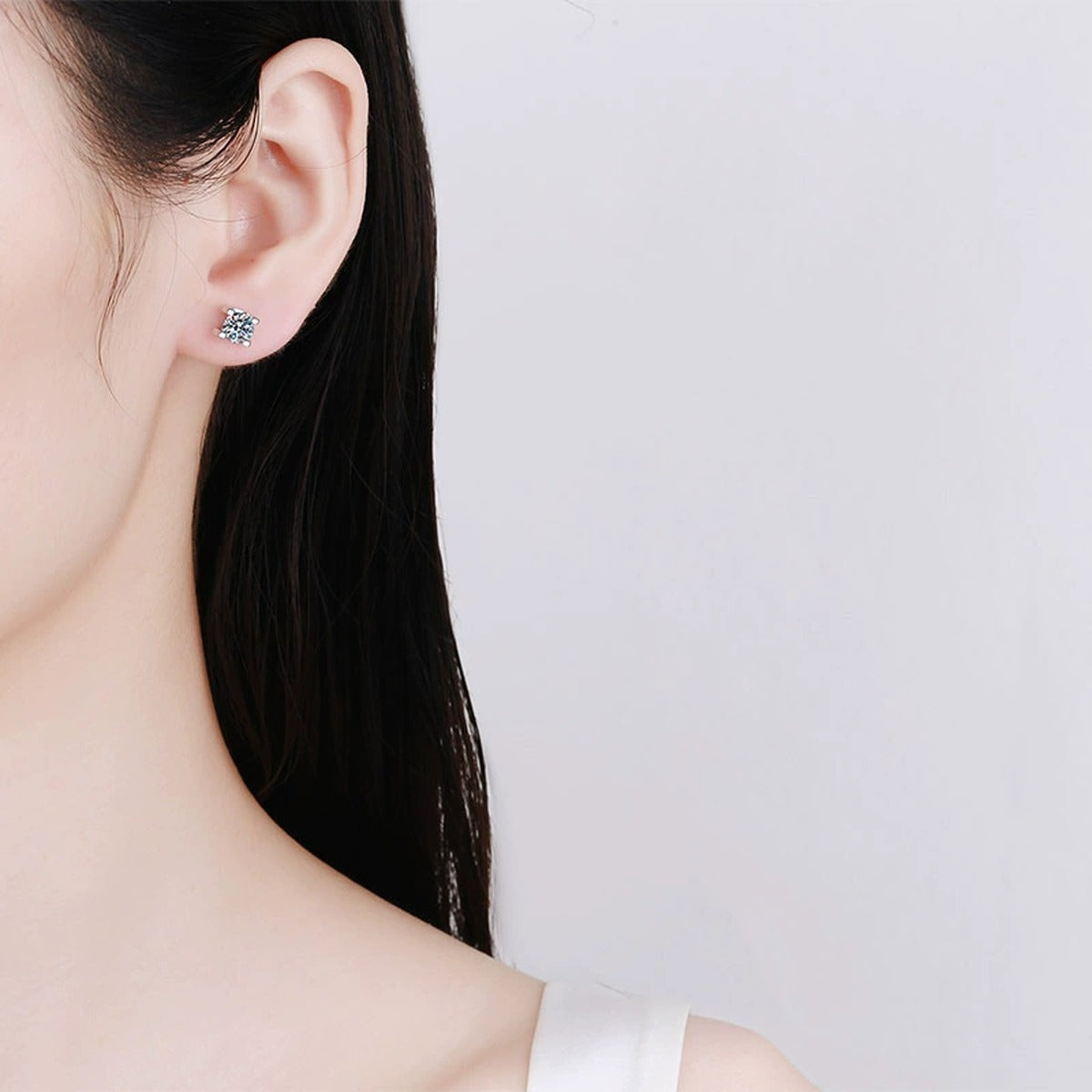Round Moissanite Stud Earrings in Rhodium-Plated S925 sterling silver worn on ear by model showing scale, placement, and stud earrings styling