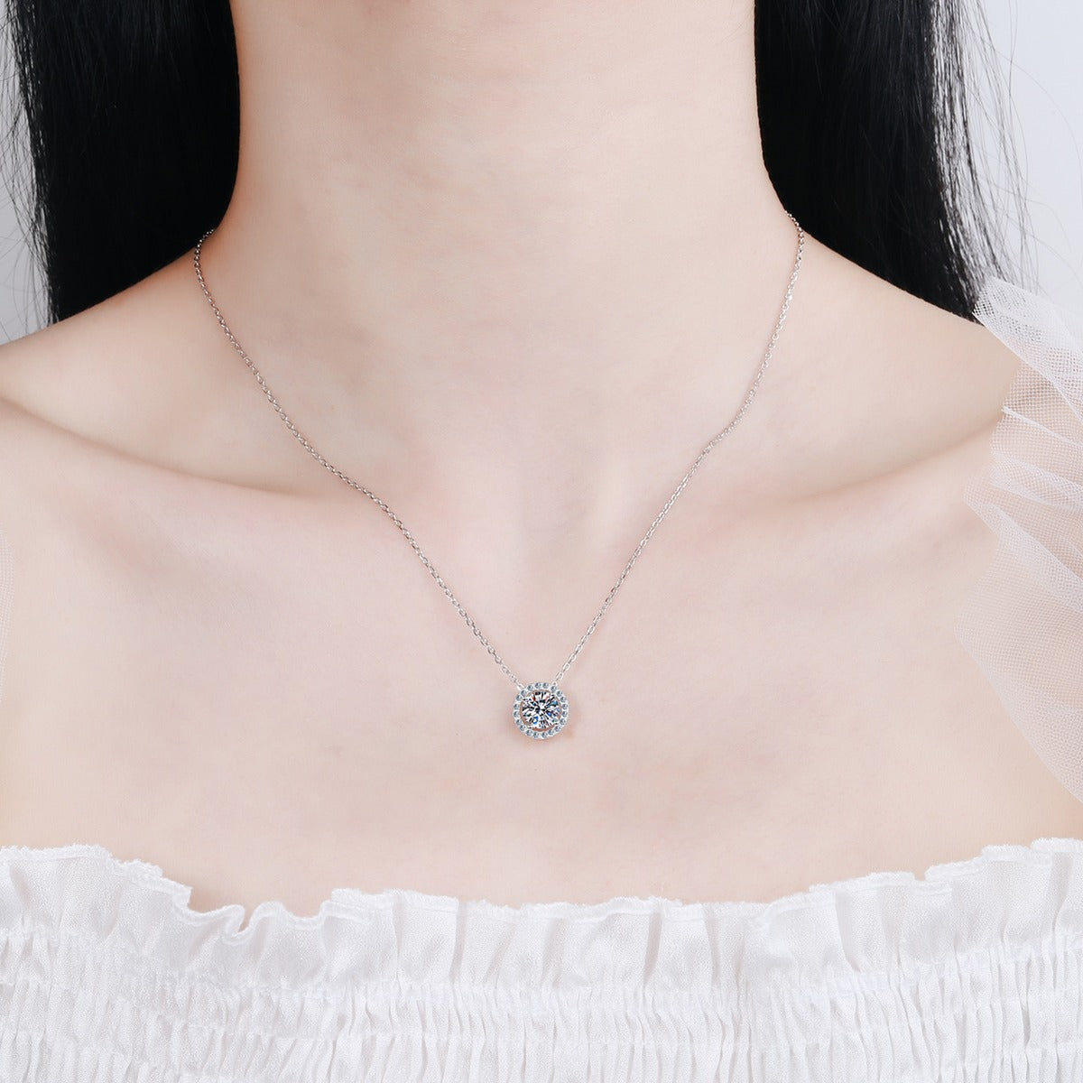 Halo Moissanite Pendant Necklace with CZ in Rhodium-Plated S925 sterling silver worn on neckline by model showing scale and adjustable chain styling