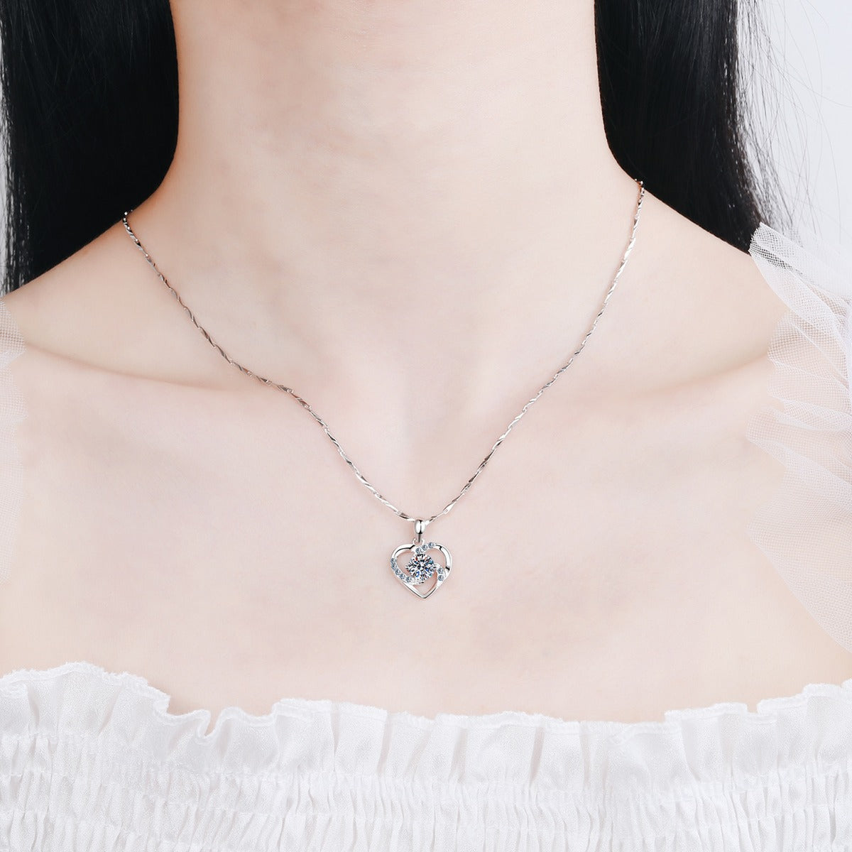 Heart Moissanite Pendant Necklace with CZ in Rhodium-Plated S925 sterling silver worn on neckline by model showing scale and adjustable chain styling