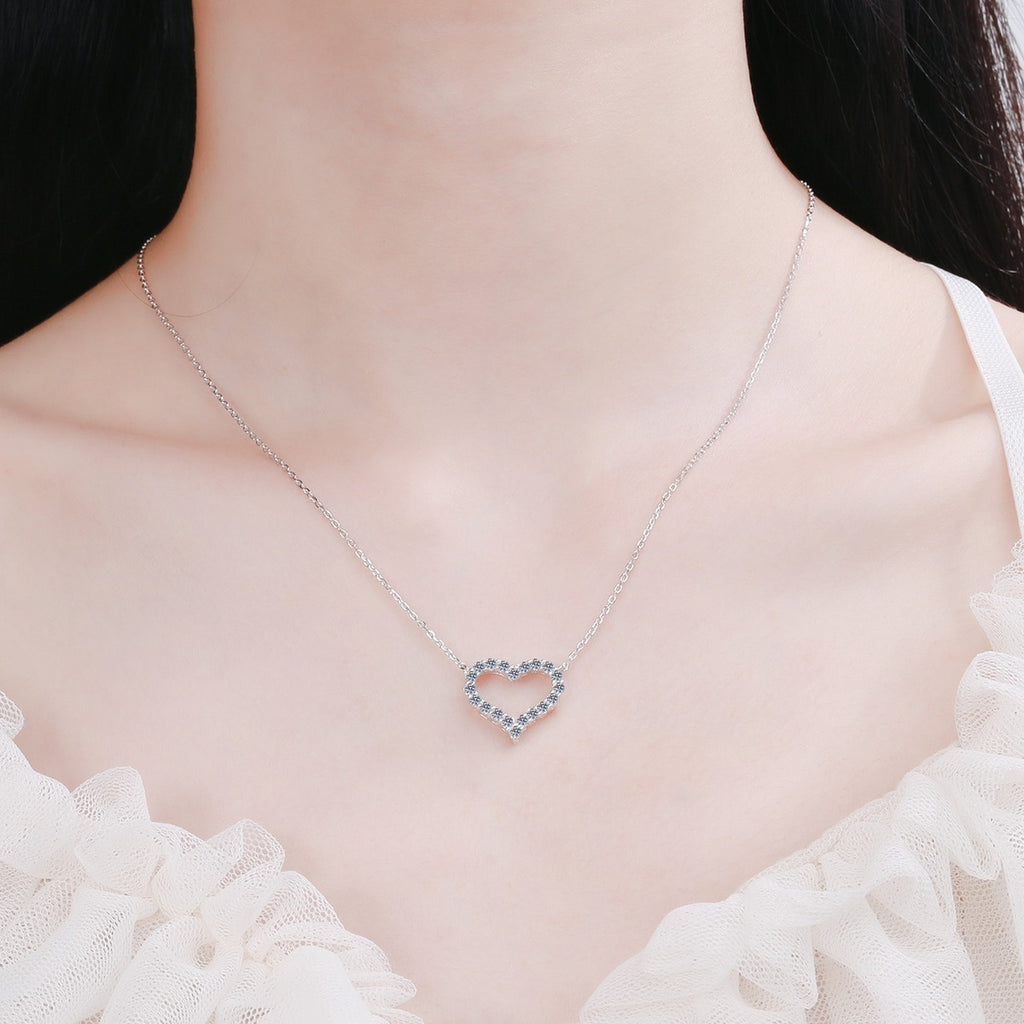 Heart Pave Moissanite Pendant Necklace in Rhodium-Plated S925 sterling silver worn on neckline by model showing scale and adjustable chain styling