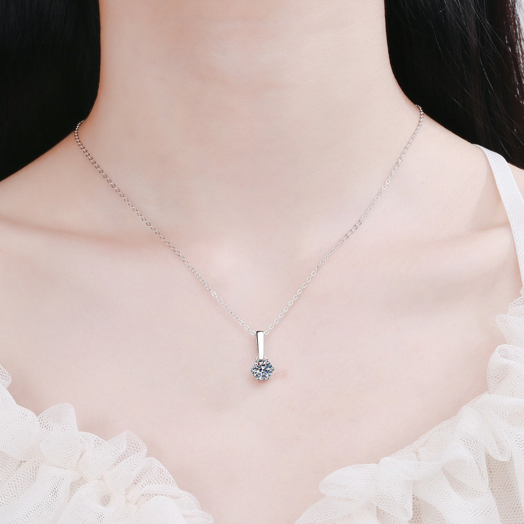 Solitaire Moissanite Pendant Necklace in Rhodium-Plated S925 sterling silver worn on neckline by model showing scale and adjustable chain styling