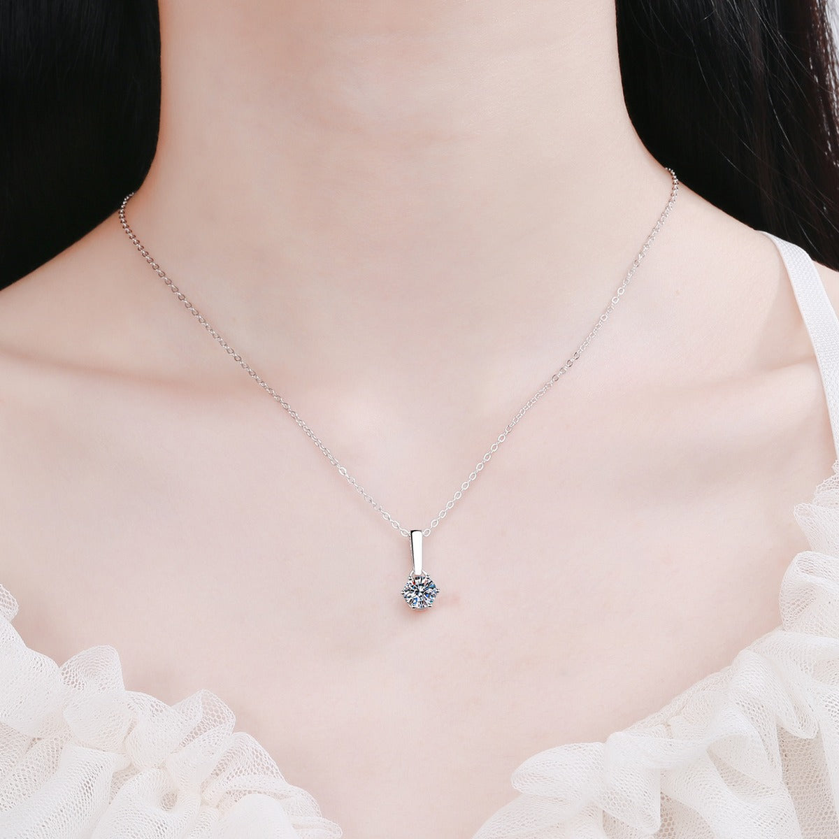 Solitaire Moissanite Pendant Necklace in Rhodium-Plated S925 sterling silver worn on neckline by model showing scale and adjustable chain styling