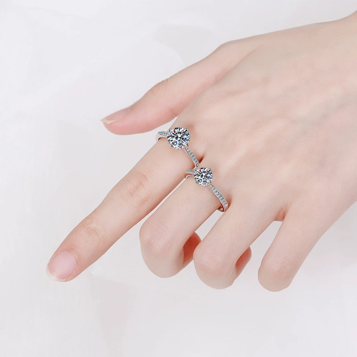 Round Moissanite Side Stone Engagement Ring with CZ worn on hand to show scale, band width, and ring profile