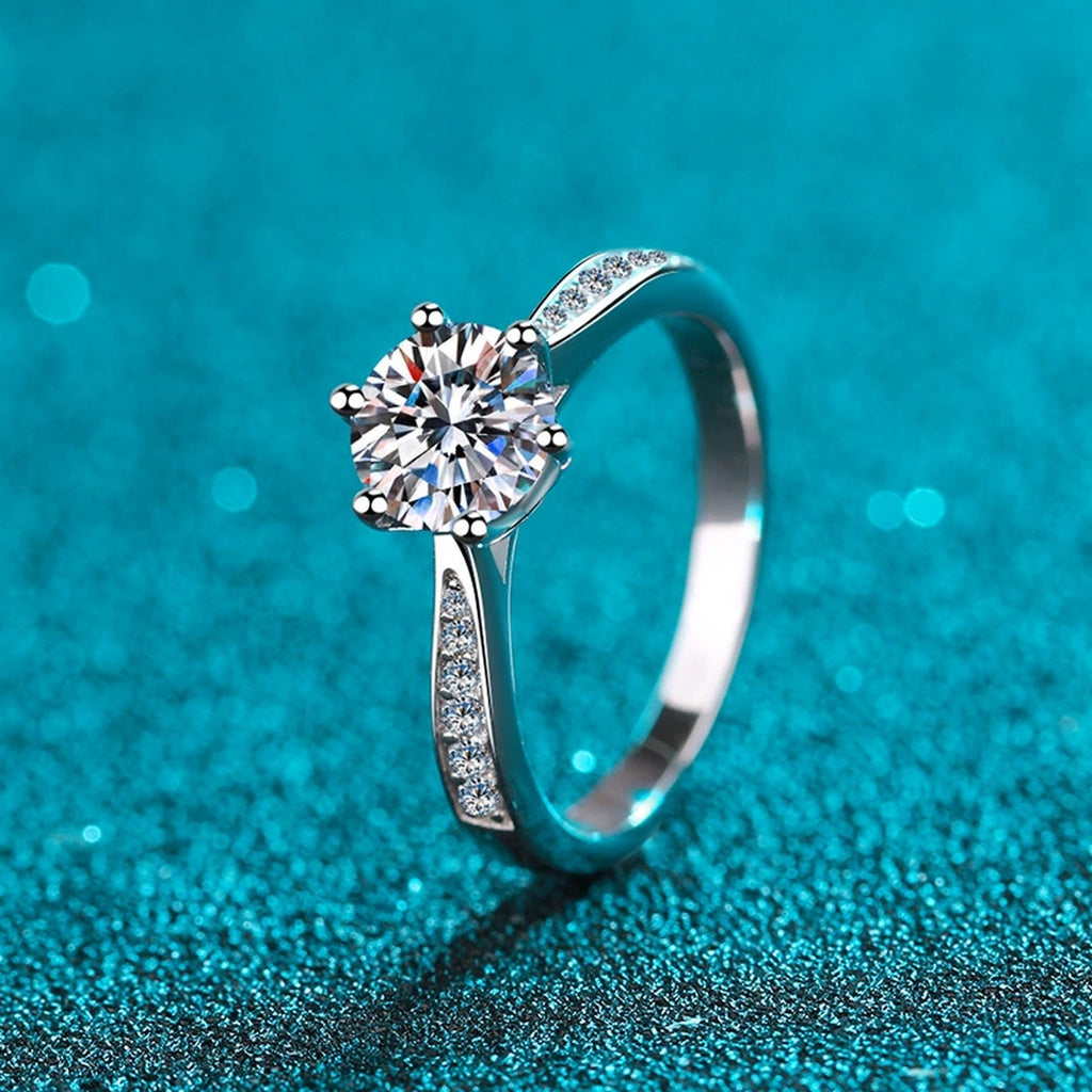 Round Moissanite Side Stone Ring with CZ in Rhodium-Plated S925 Sterling Silver blue display product photo showing the moissanite setting and band profile