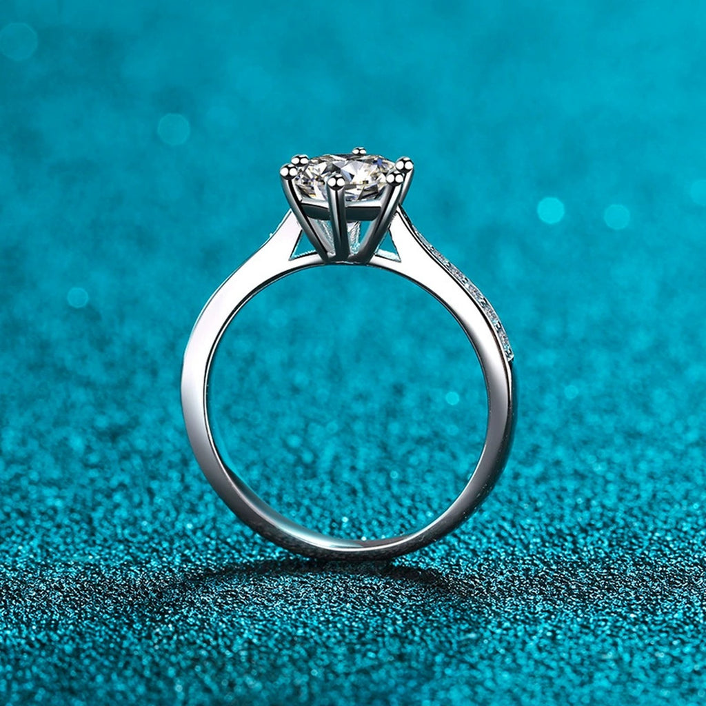 Round Moissanite Side Stone Ring with CZ in Rhodium-Plated S925 Sterling Silver blue display product photo showing the moissanite setting and band profile