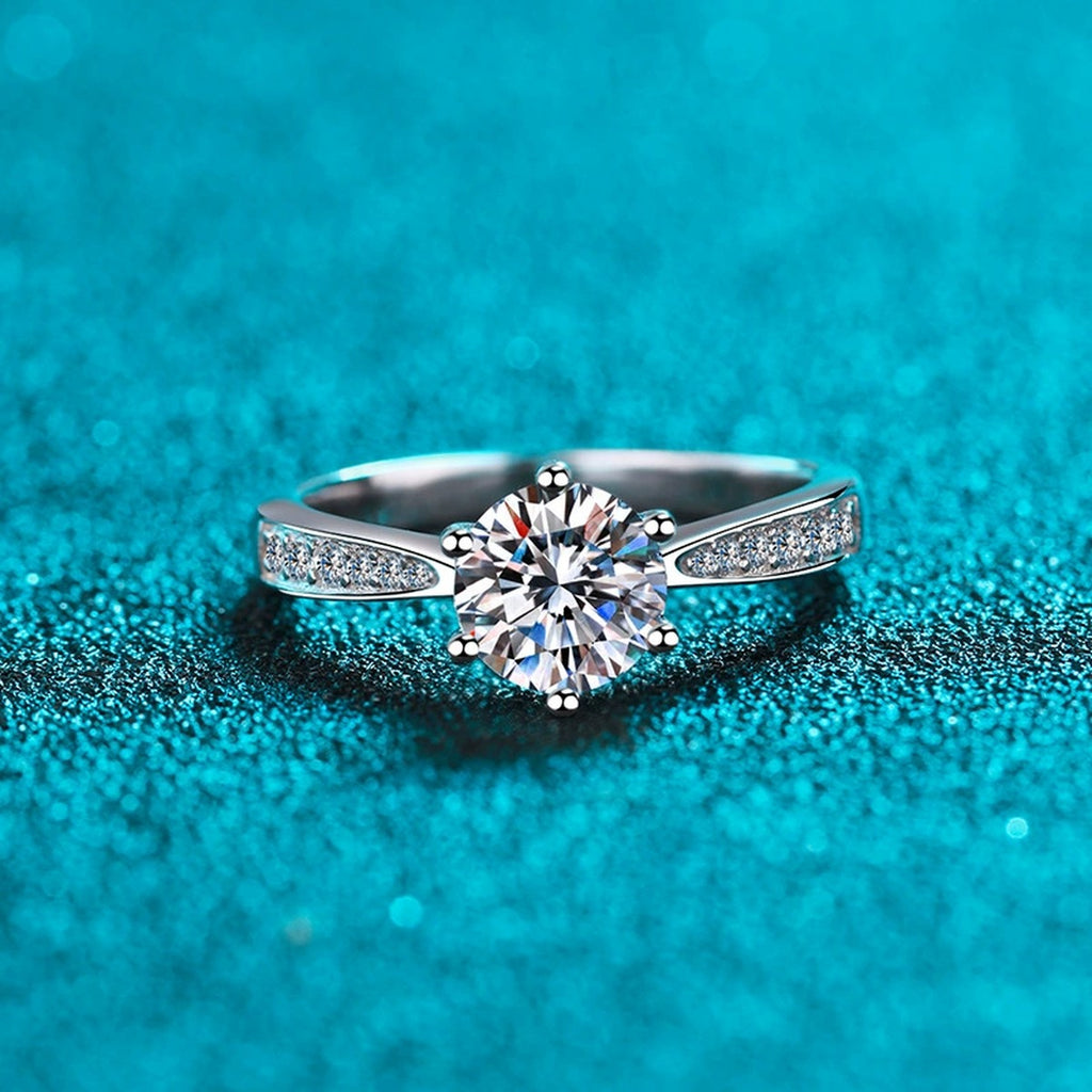 Round Moissanite Side Stone Ring with CZ in Rhodium-Plated S925 Sterling Silver blue display product photo showing the moissanite setting and band profile