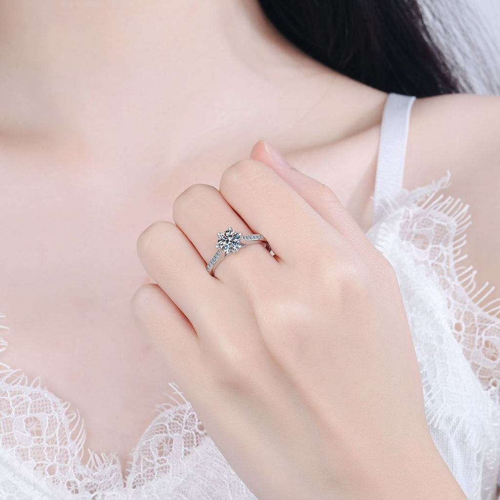 Round Moissanite Side Stone Engagement Ring with CZ worn on hand to show scale, band width, and ring profile