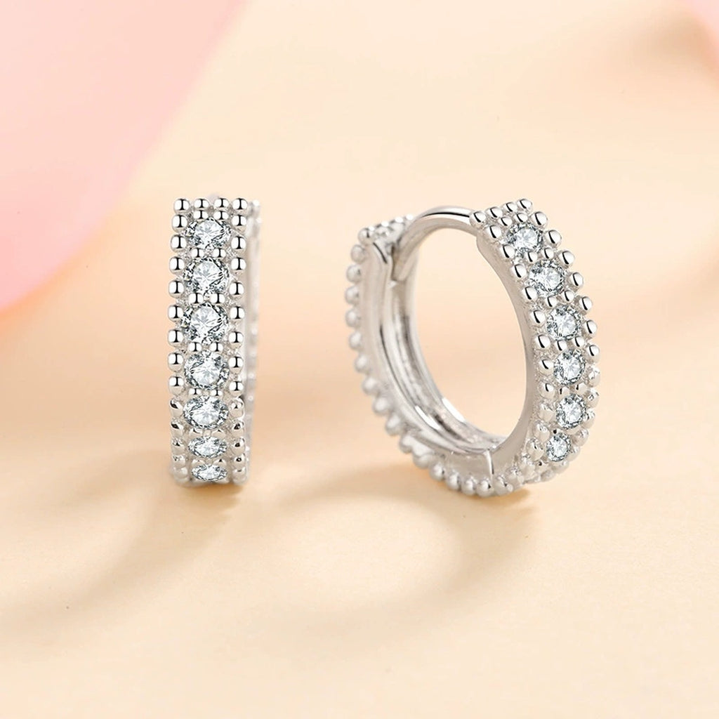 Pavé Moissanite Huggie Hoop Earrings in Rhodium-Plated S925 sterling silver product scene view showing front sparkle