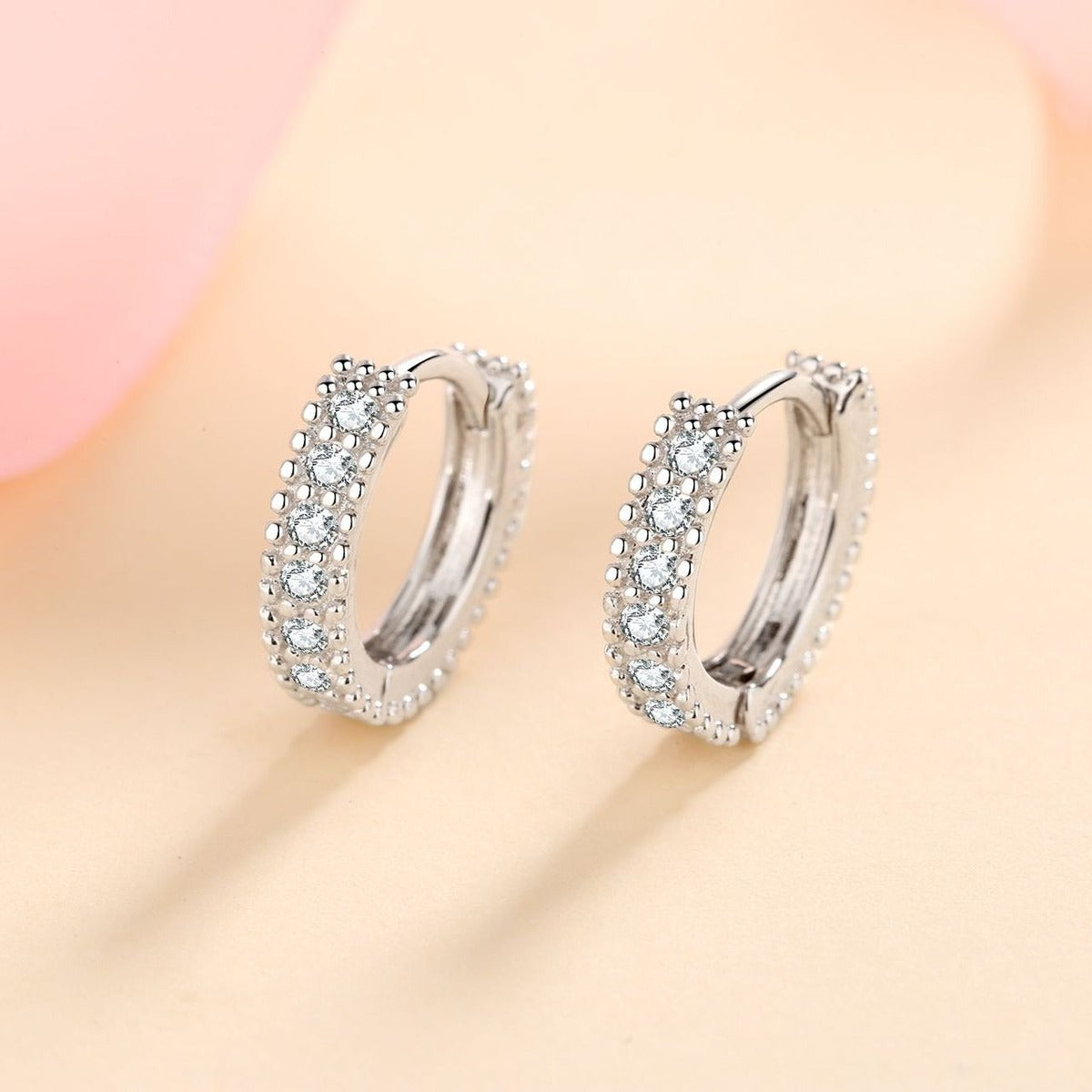 Pavé Moissanite Huggie Hoop Earrings in Rhodium-Plated S925 sterling silver product scene view showing angled setting detail