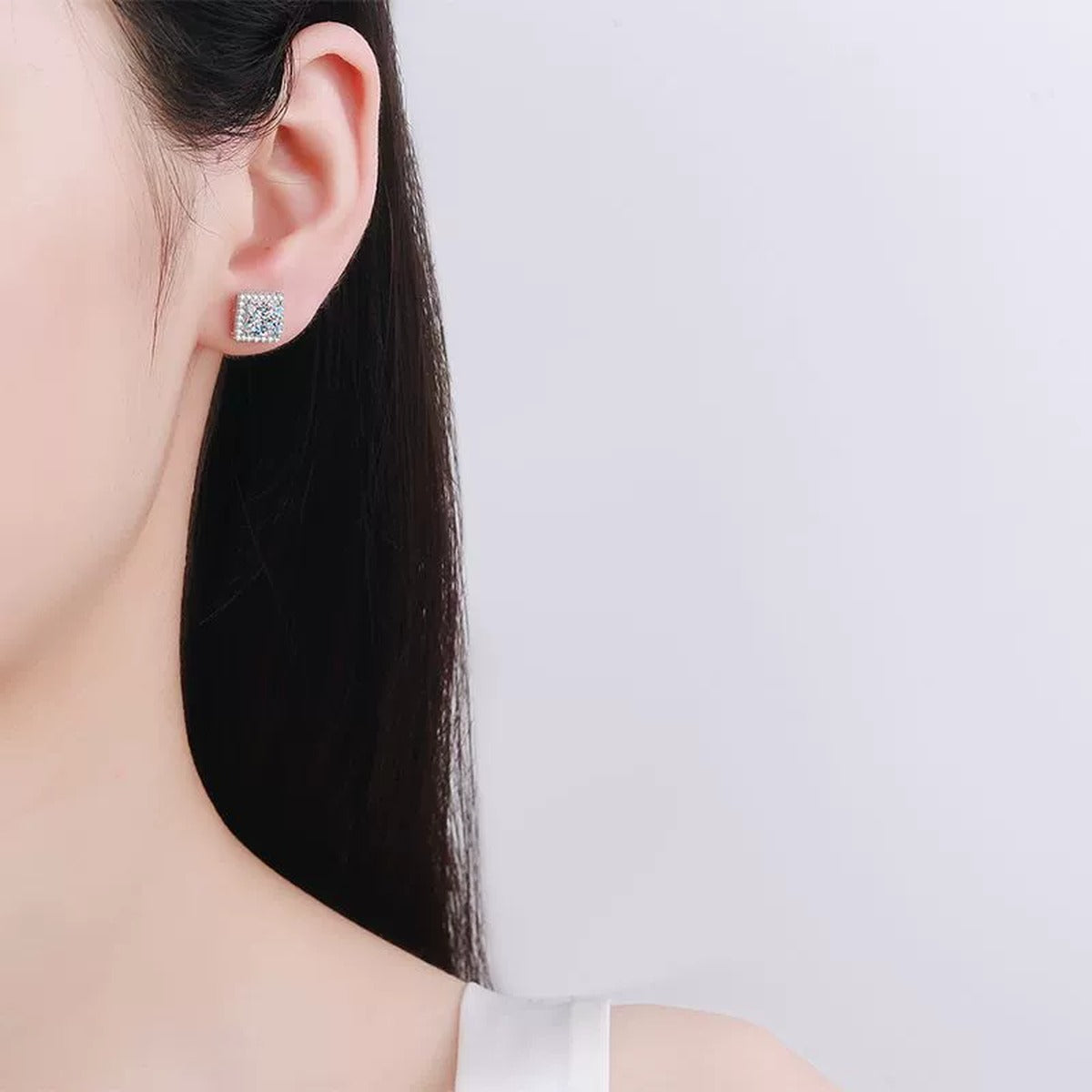 Princess Cut Moissanite Stud Earrings with CZ in Rhodium-Plated S925 sterling silver worn on ear by model showing scale, placement, and stud earrings styling