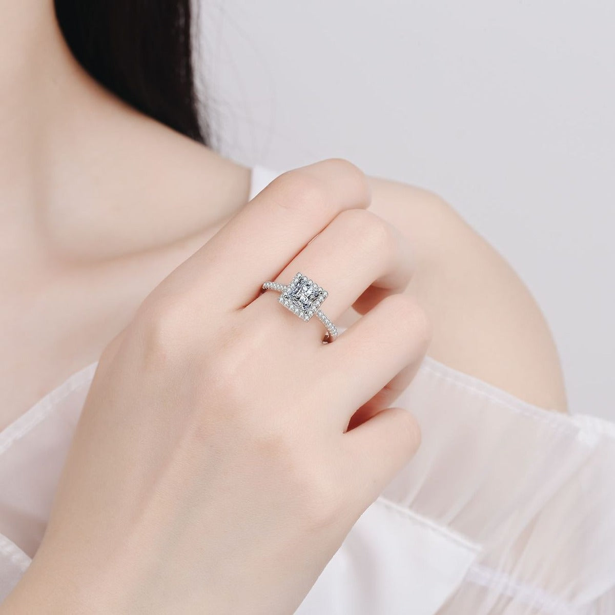 Princess Cut Moissanite Halo Engagement Ring with CZ worn on hand to show scale, band width, and ring profile
