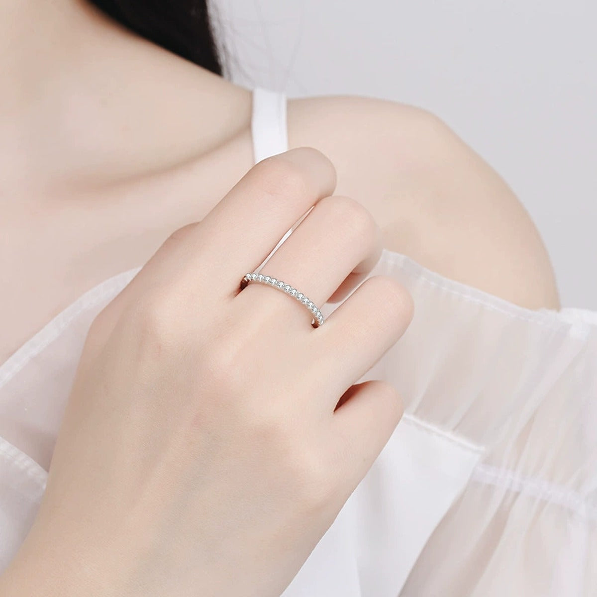 Moissanite Eternity Band Ring in Rhodium-Plated S925 Sterling Silver worn on hand, showing scale, finger coverage, and rhodium-plated finish