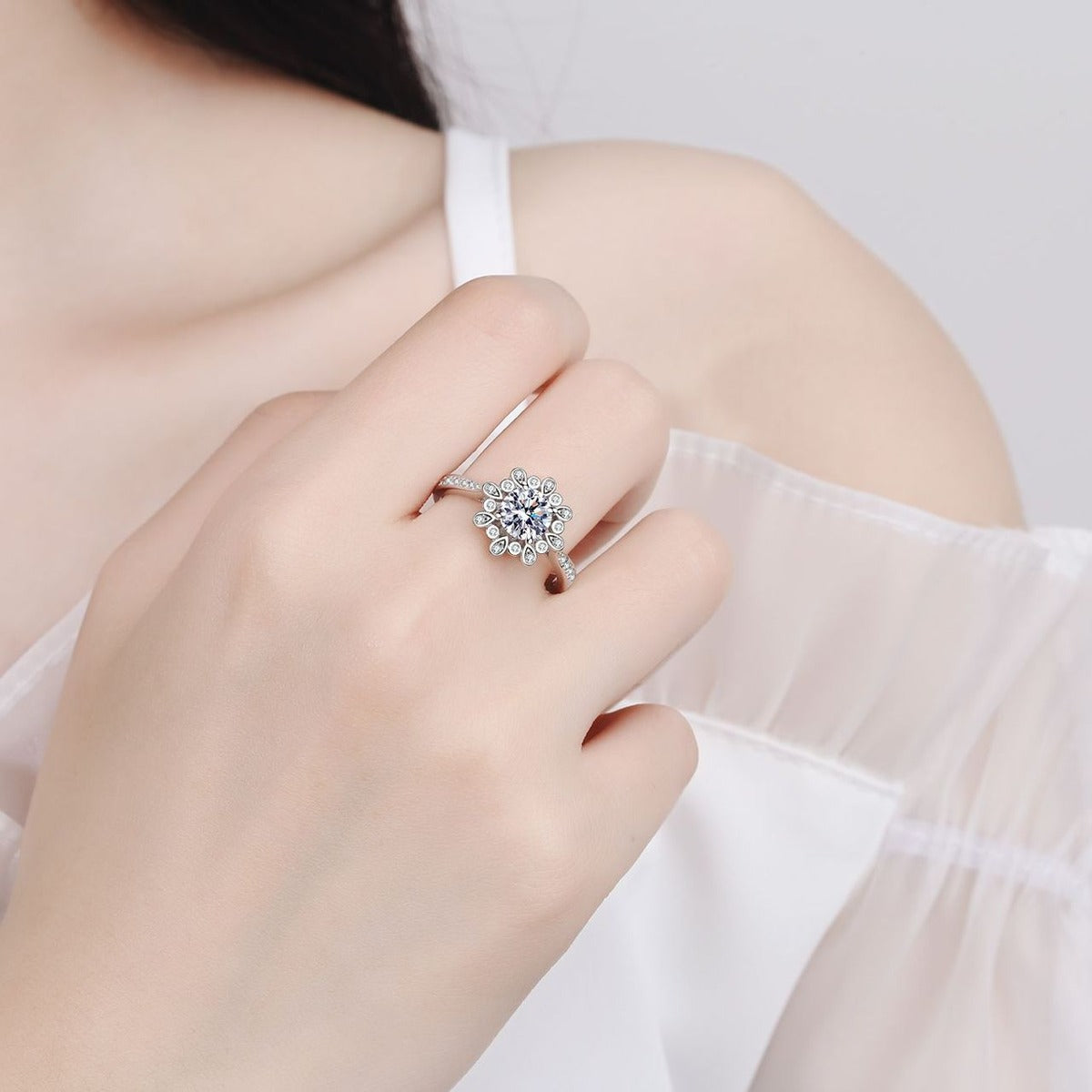Round Floral Halo Moissanite Ring with CZ worn on hand to show scale, band width, and ring profile
