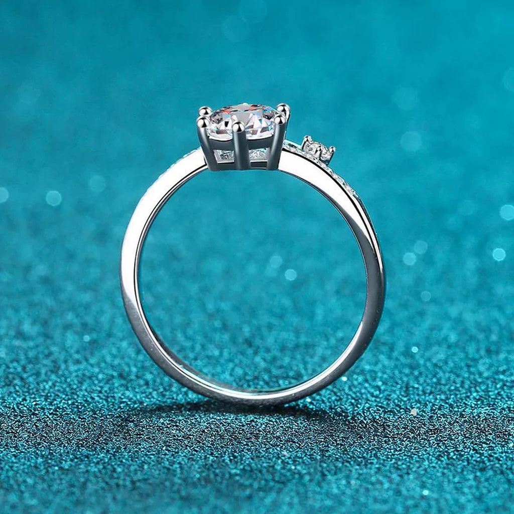 Round Moissanite Side Stone Ring with CZ in Rhodium-Plated S925 Sterling Silver blue display product photo showing the moissanite setting and band profile