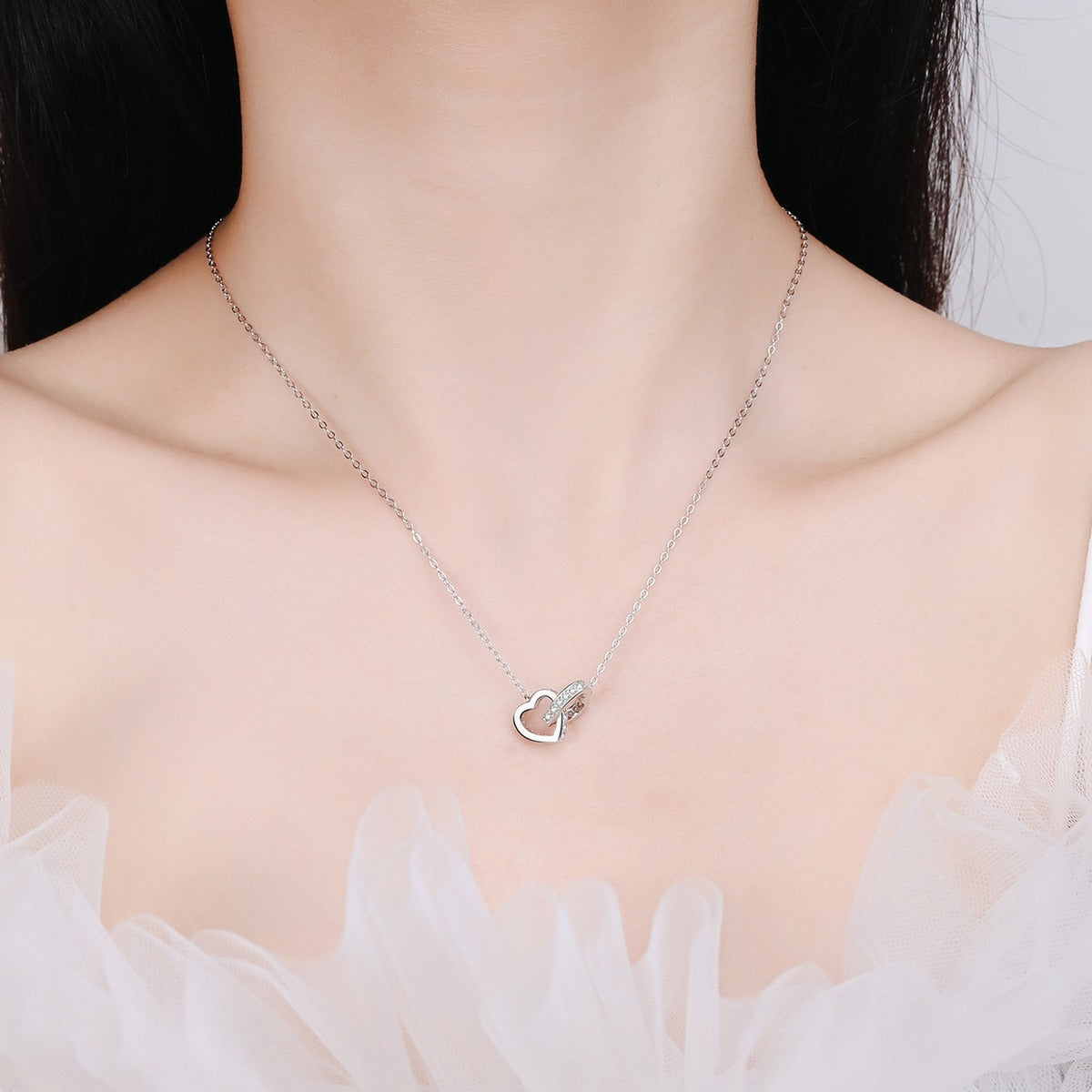 Linked Heart Moissanite Pendant Necklace in Rhodium and Rose Gold-Plated S925 sterling silver worn on neckline by model showing scale and adjustable chain styling