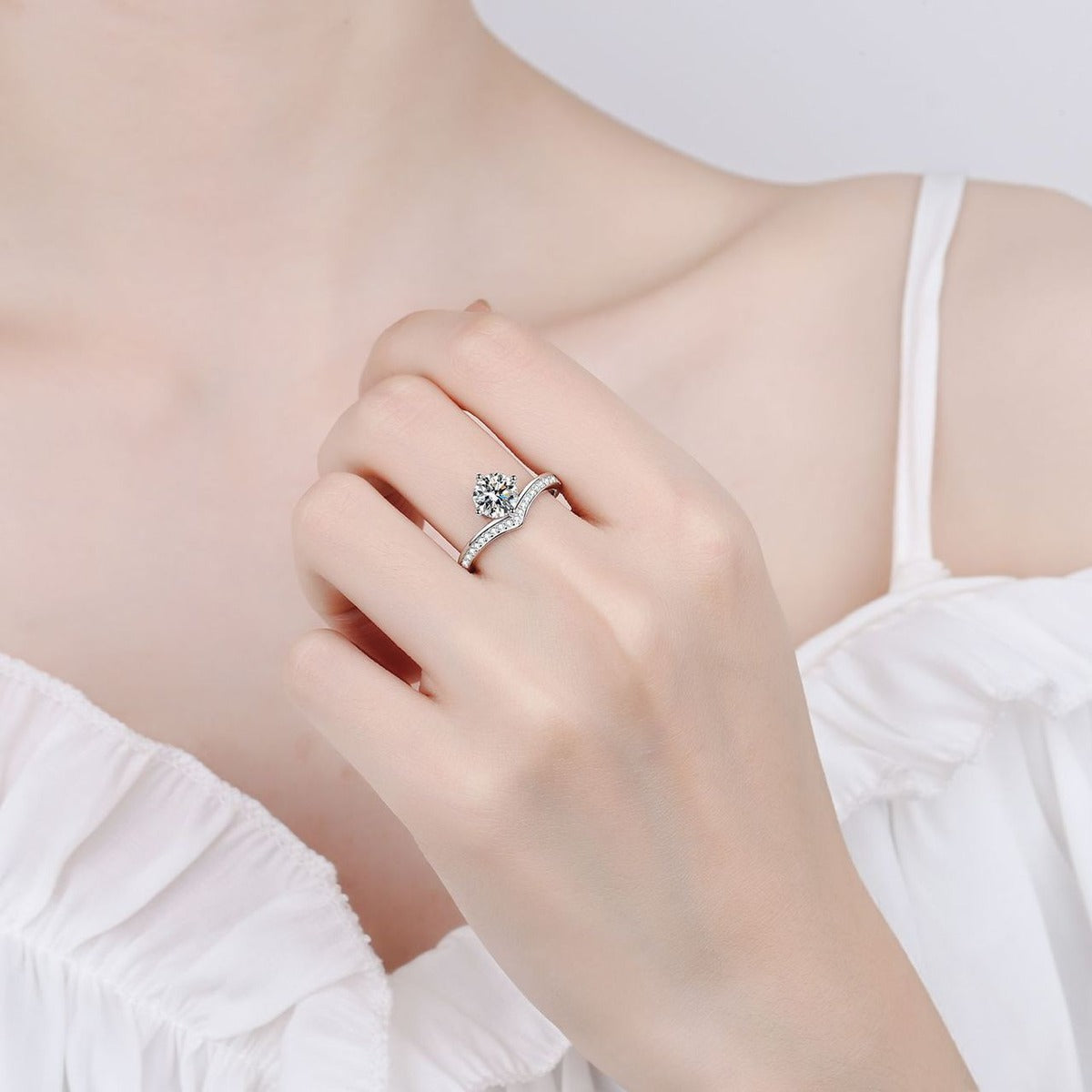 Round Moissanite Side Stone Engagement Ring with CZ worn on hand to show scale, band width, and ring profile