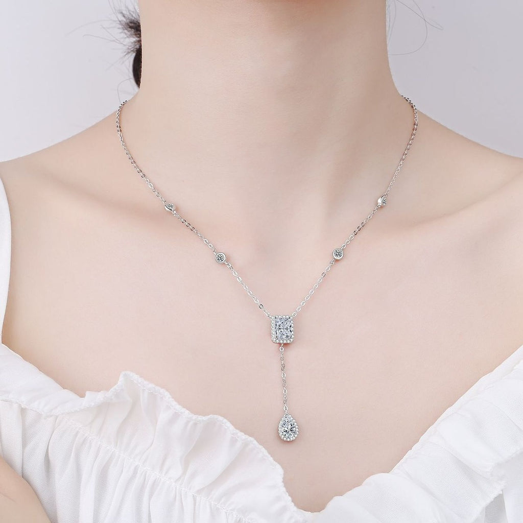 Radiant and Pear Moissanite Charm Necklace with CZ in Rhodium-Plated S925 sterling silver worn on neckline by model showing scale and adjustable chain styling