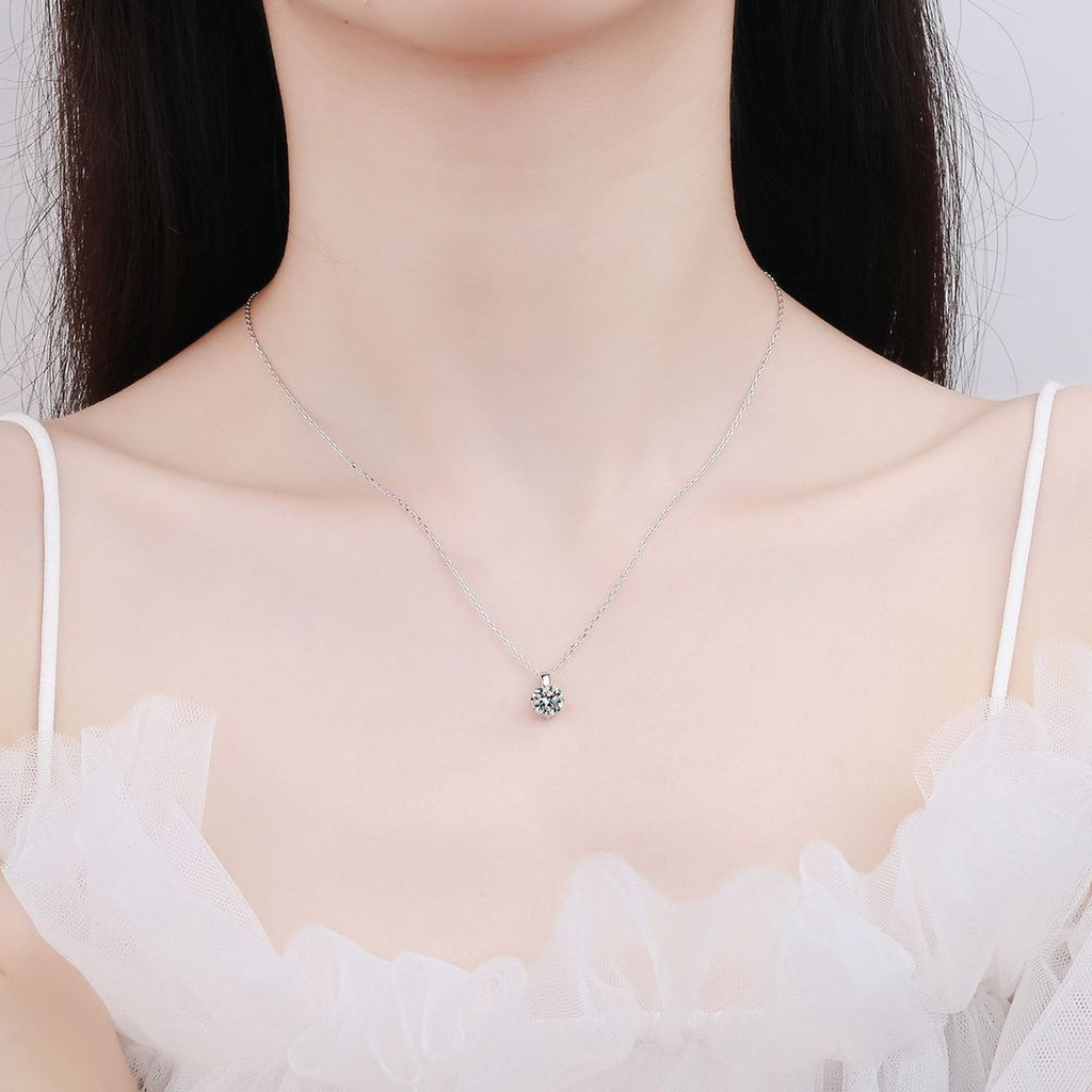 Solitaire Moissanite Pendant Necklace in Rhodium-Plated S925 sterling silver worn on neckline by model showing scale and adjustable chain styling