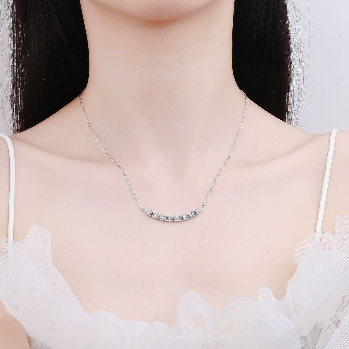 Smile Curve Moissanite Pendant Necklace with CZ in Rhodium-Plated S925 sterling silver worn on neckline by model showing scale and adjustable chain styling