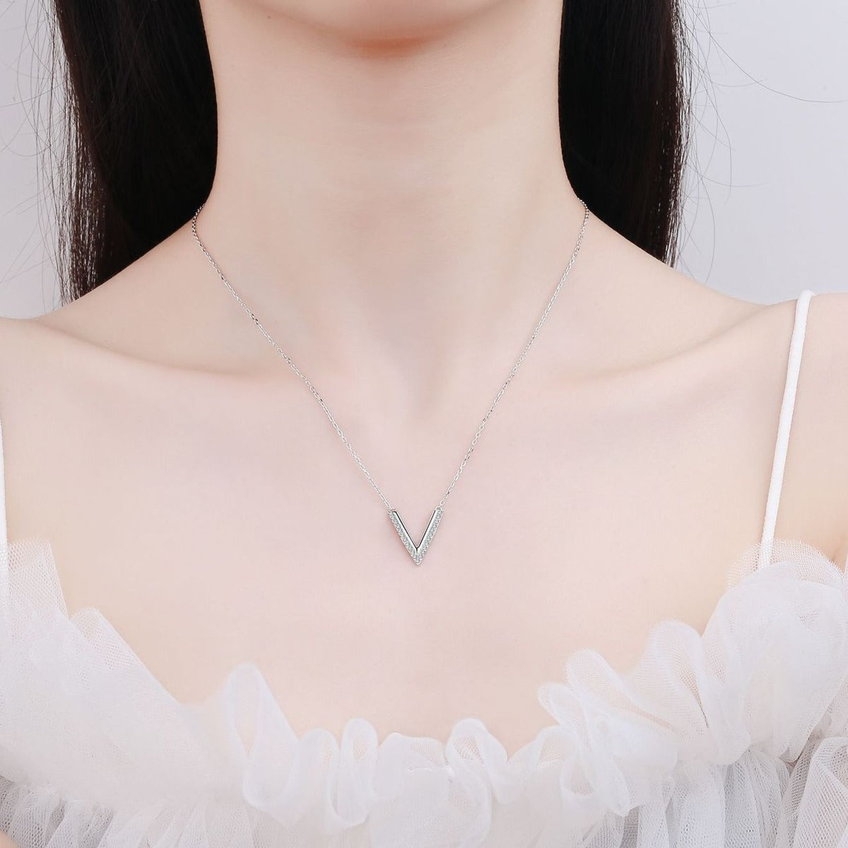 V-Shaped Moissanite Pendant Necklace in Rhodium-Plated S925 sterling silver worn on neckline by model showing scale and adjustable chain styling