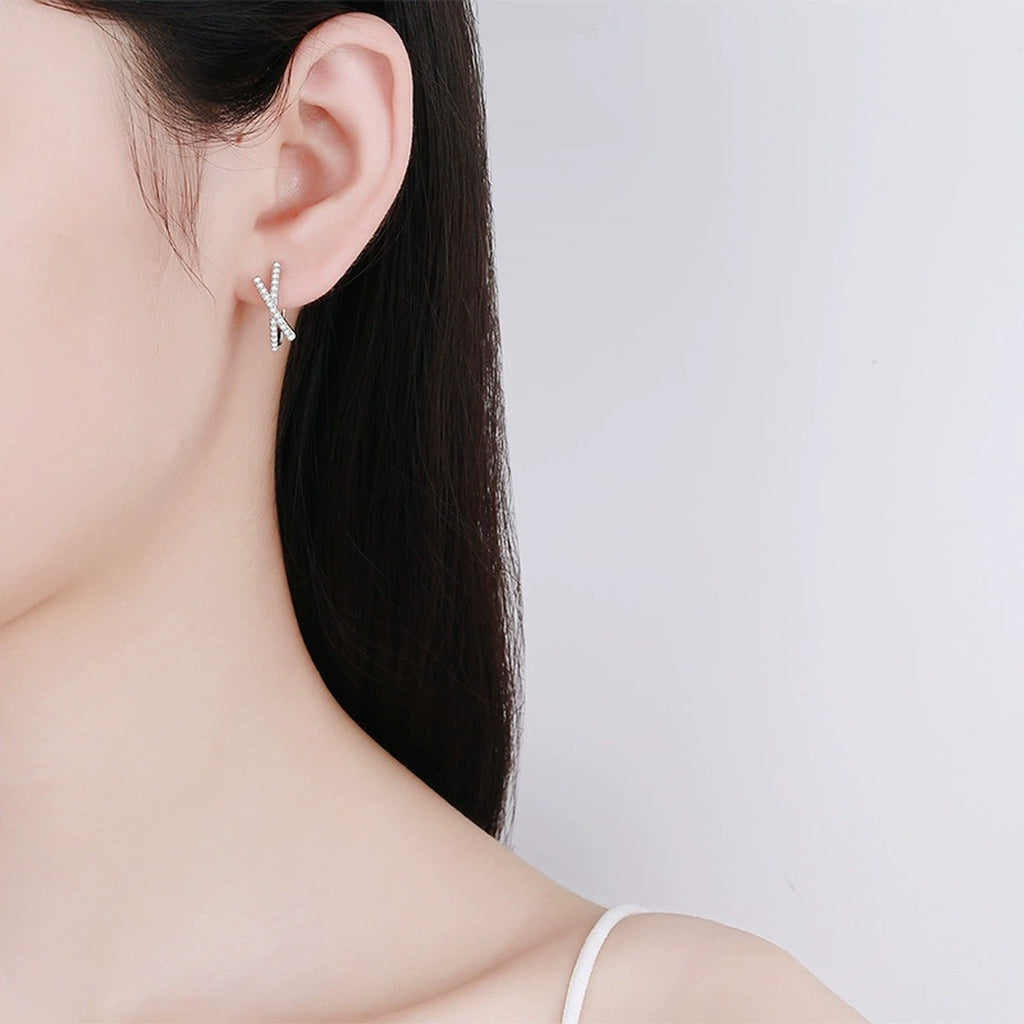 Twist Moissanite Huggie Hoop Earrings in Rhodium-Plated S925 sterling silver worn on ear by model showing scale, placement, and huggie hoop earrings styling