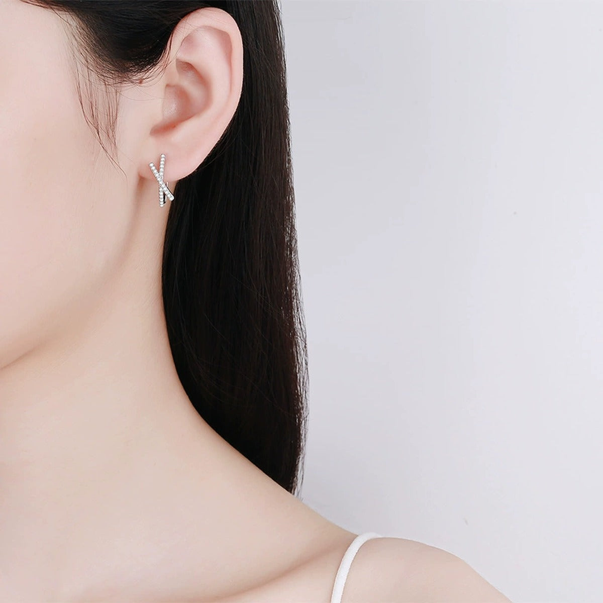 Twist Moissanite Huggie Hoop Earrings in Rhodium-Plated S925 sterling silver worn on ear by model showing scale, placement, and huggie hoop earrings styling